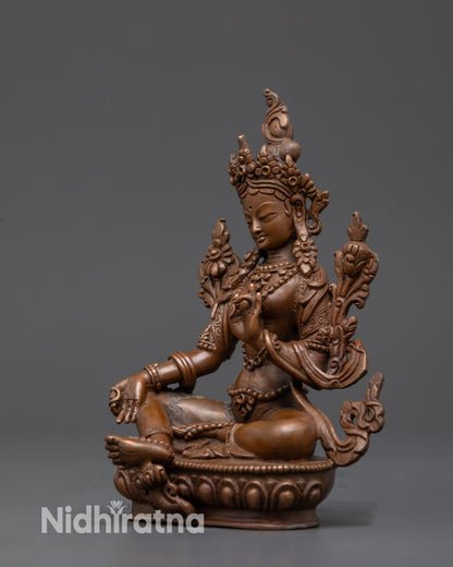 Side view Handcrafted Green Tara sculpture in royal ease mudra holding Utpala flower

