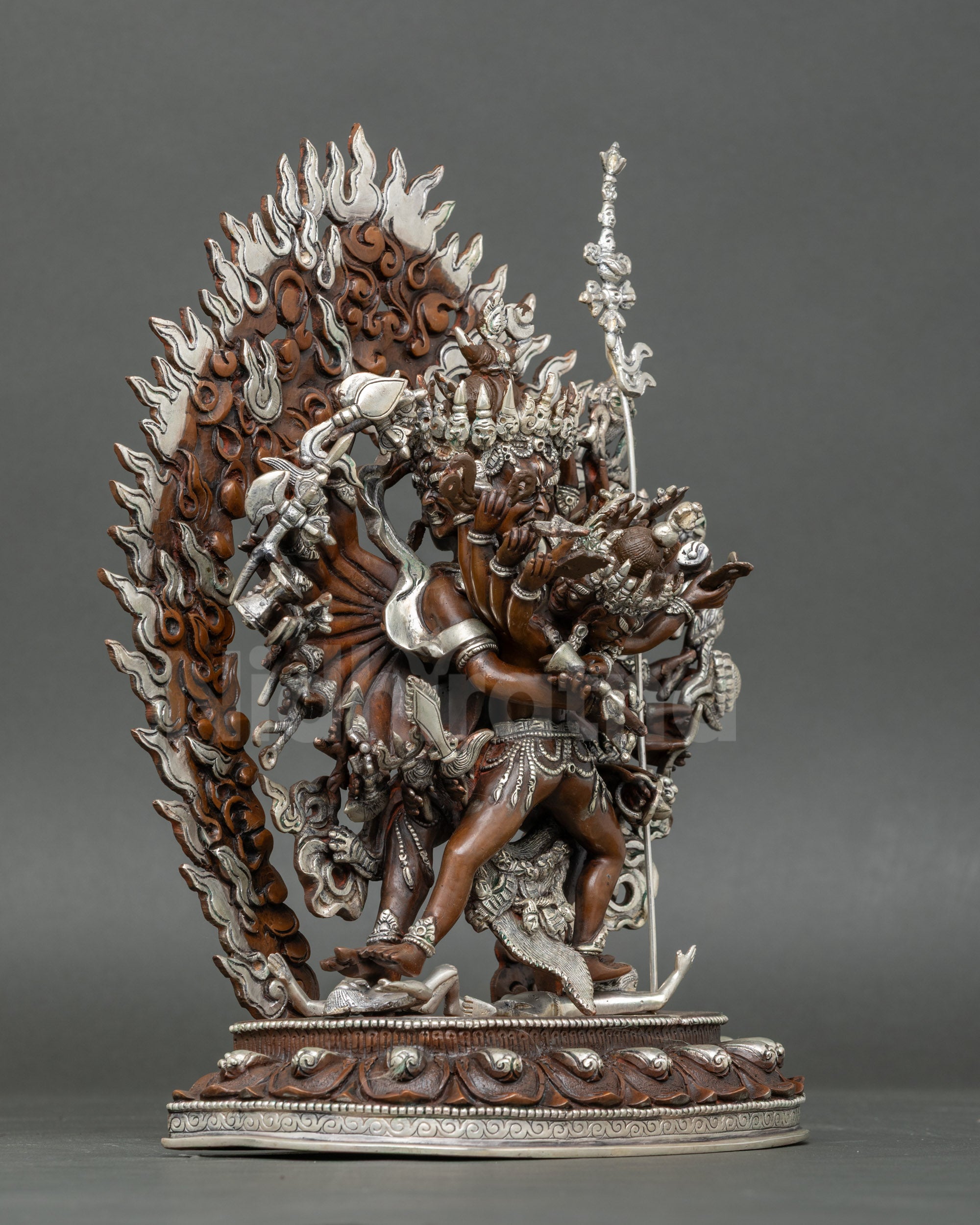 Side view Kalachakra Tantra statue with multiple arms and ritual implements