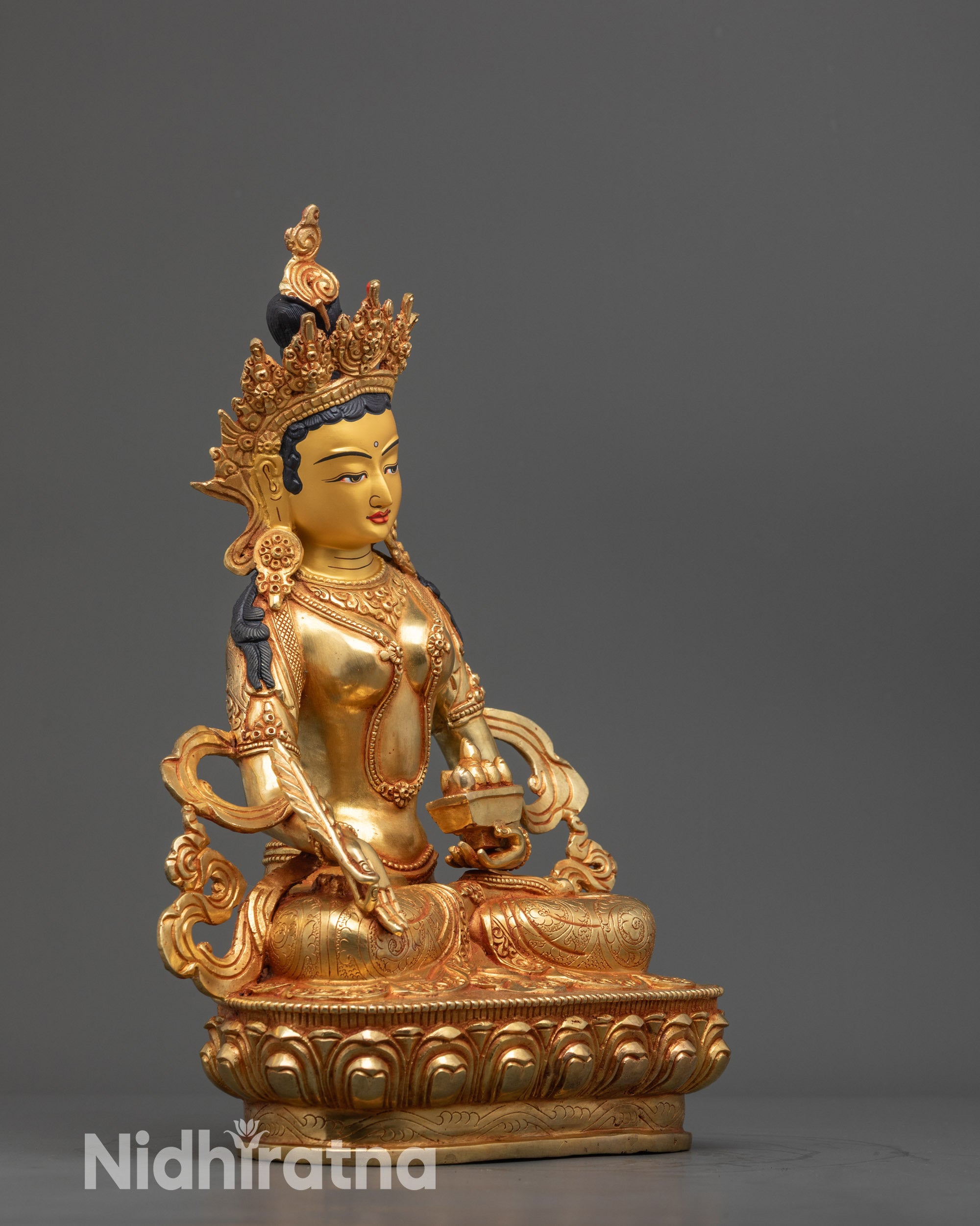 Side view Ksitigarbha Statue holding Chintamani and feathers in serene posture
