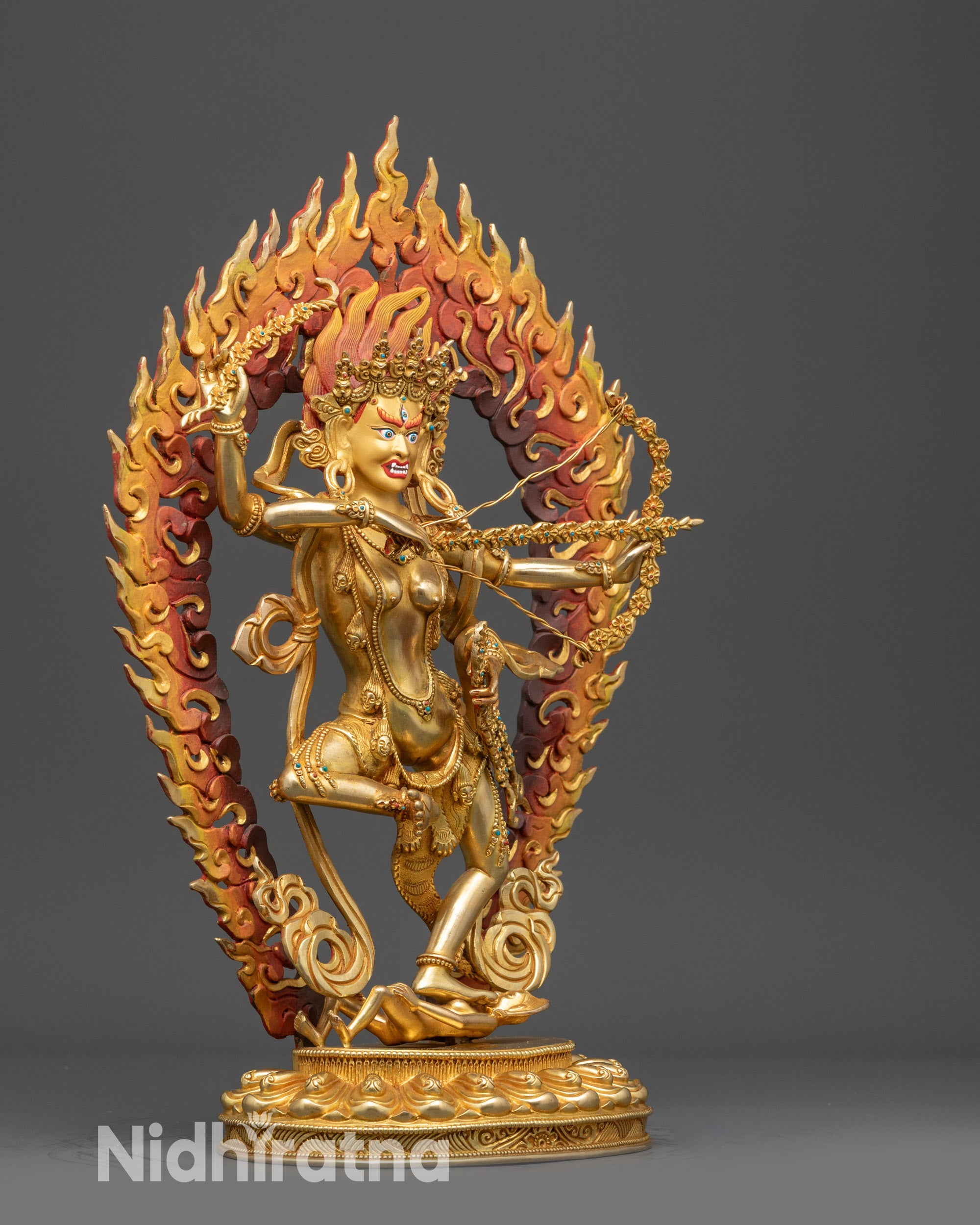 Side view Kurukulla statue with four arms and blazing halo displaying dynamic posture
