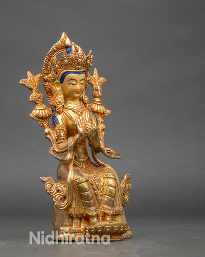 Side view Maitreya Buddha statue showing serene smile and poised teaching posture