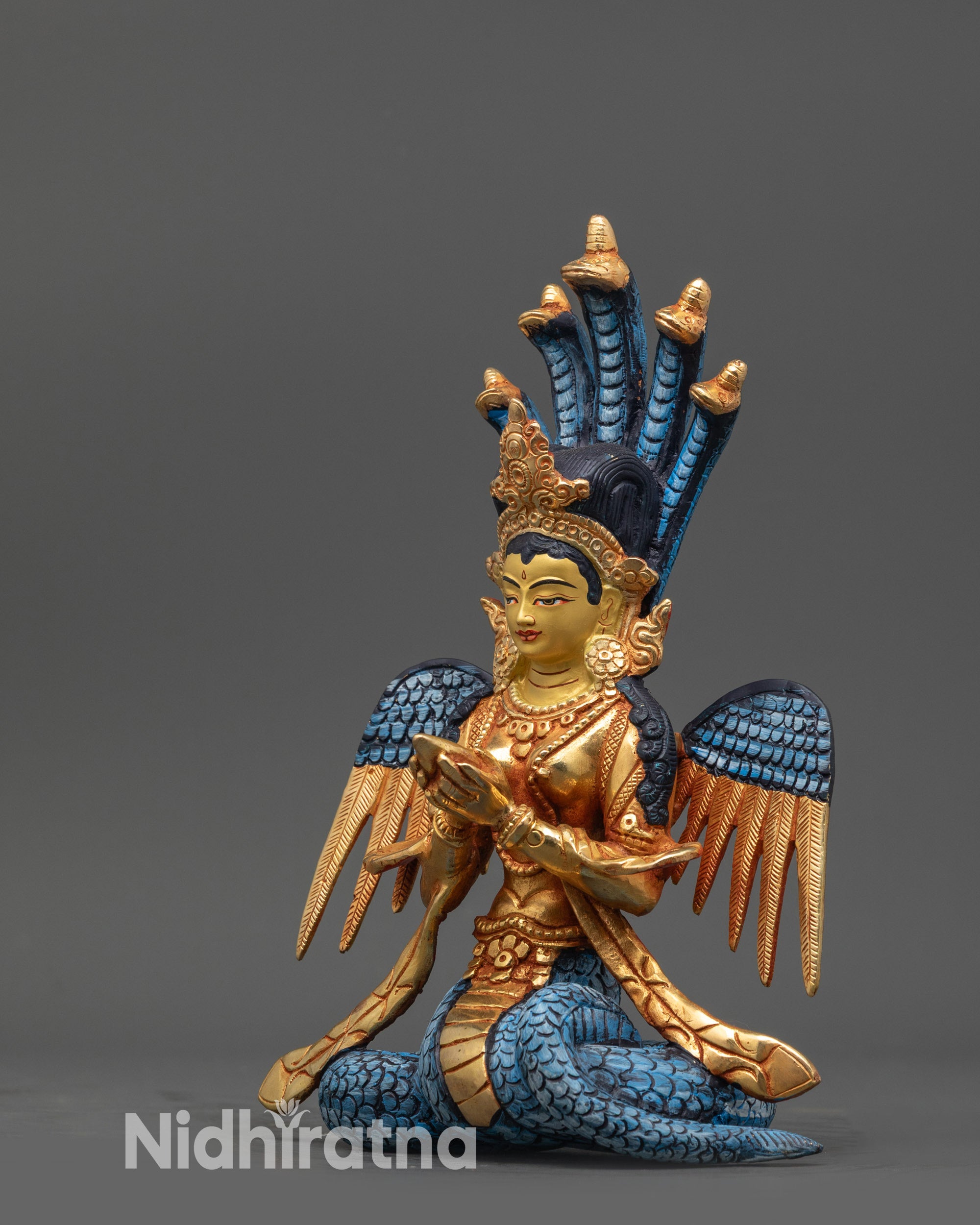 Side view Naga Kanya Sculpture showing flowing robes and half-coloured wings
