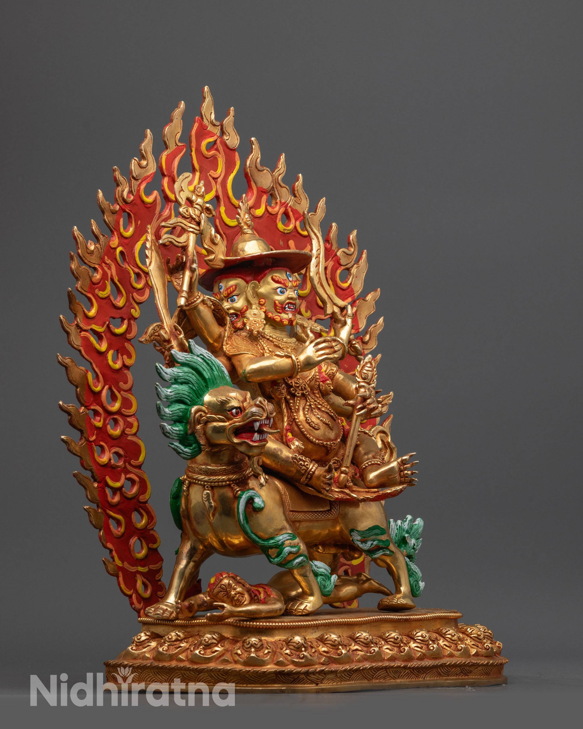 Side view Pehar Gyalpo statue riding snow lion with fire ring and broad round hat
