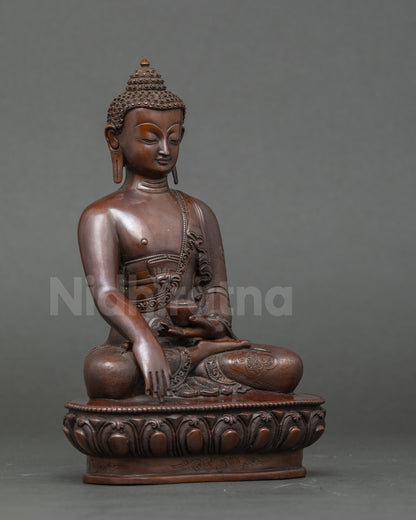 Side view Shakyamuni Buddha sculpture, seated on lotus throne holding patra bowl