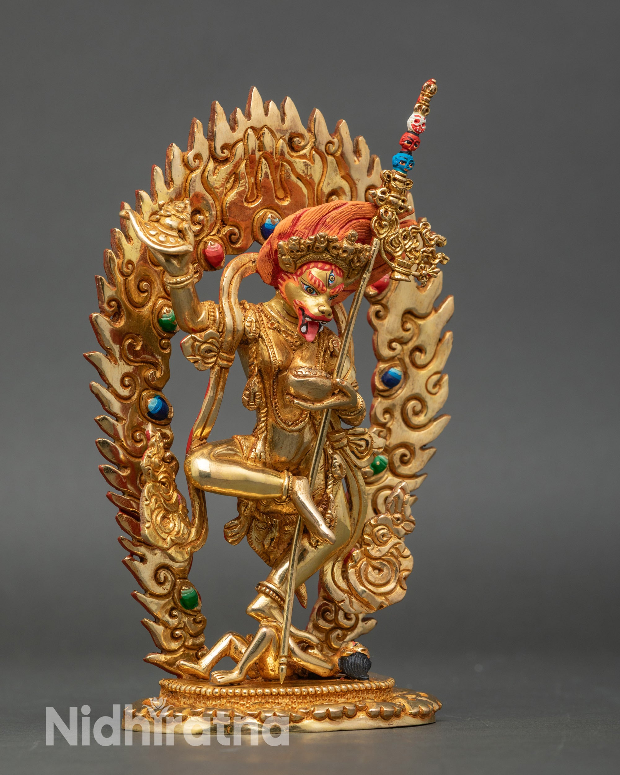 Side view: Side view Simha Mukha Dakini statue, holding curved knife and skull cup, flaming halo detail