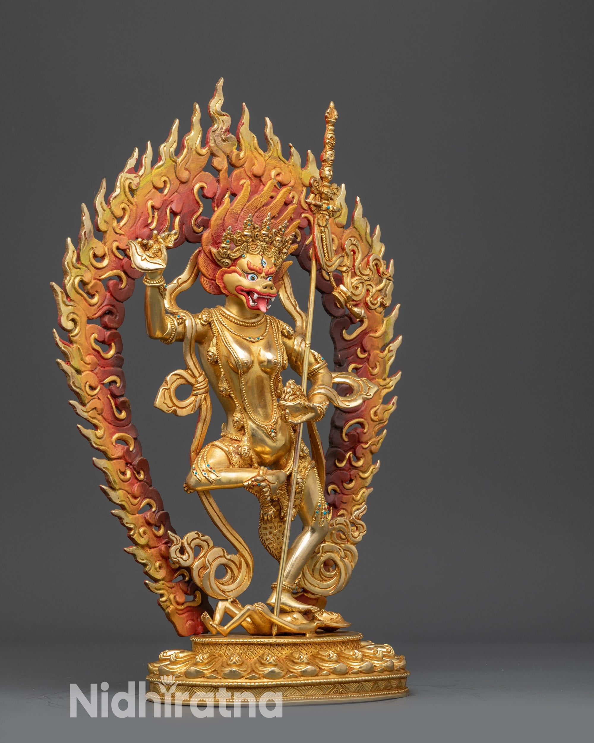 Side view Simha Mukha statue with swirling robes, kartika knife, and khatvanga trident