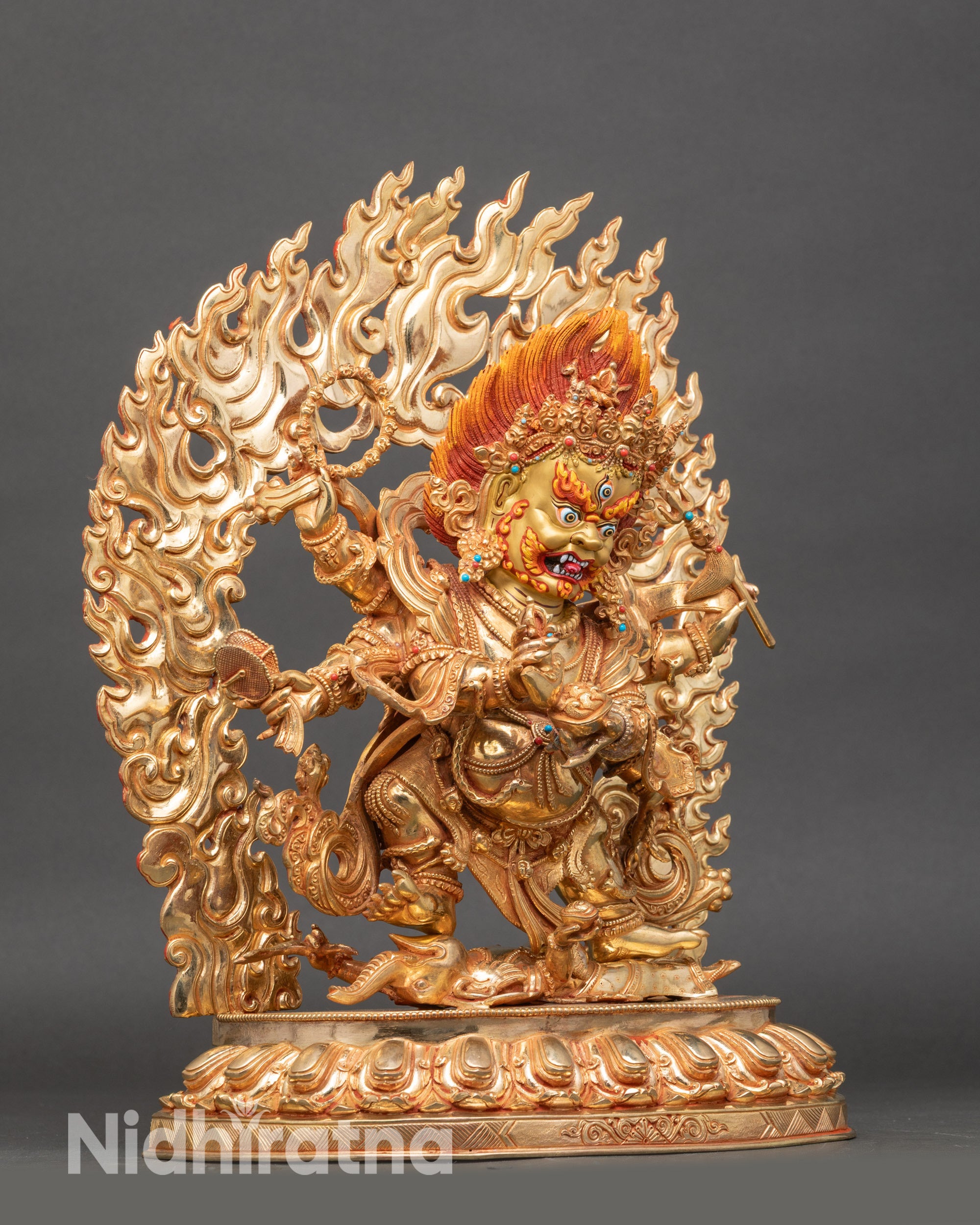 Side view Six-Armed Mahakala sculpture holding kartika, kapala, trisula, damaru, and lasso