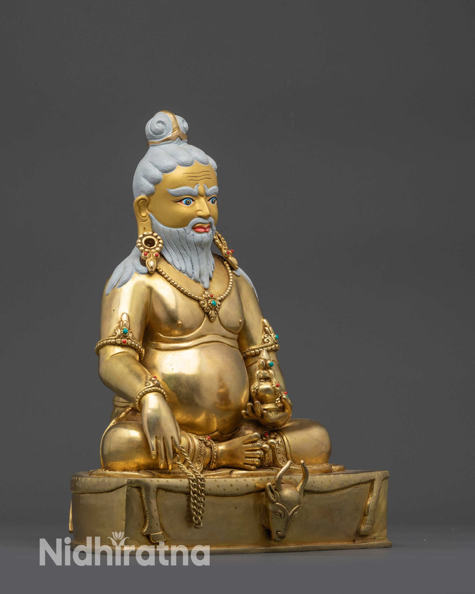 Side view Thangtong Gyalpo statue showing chain, vase, and flowing garments