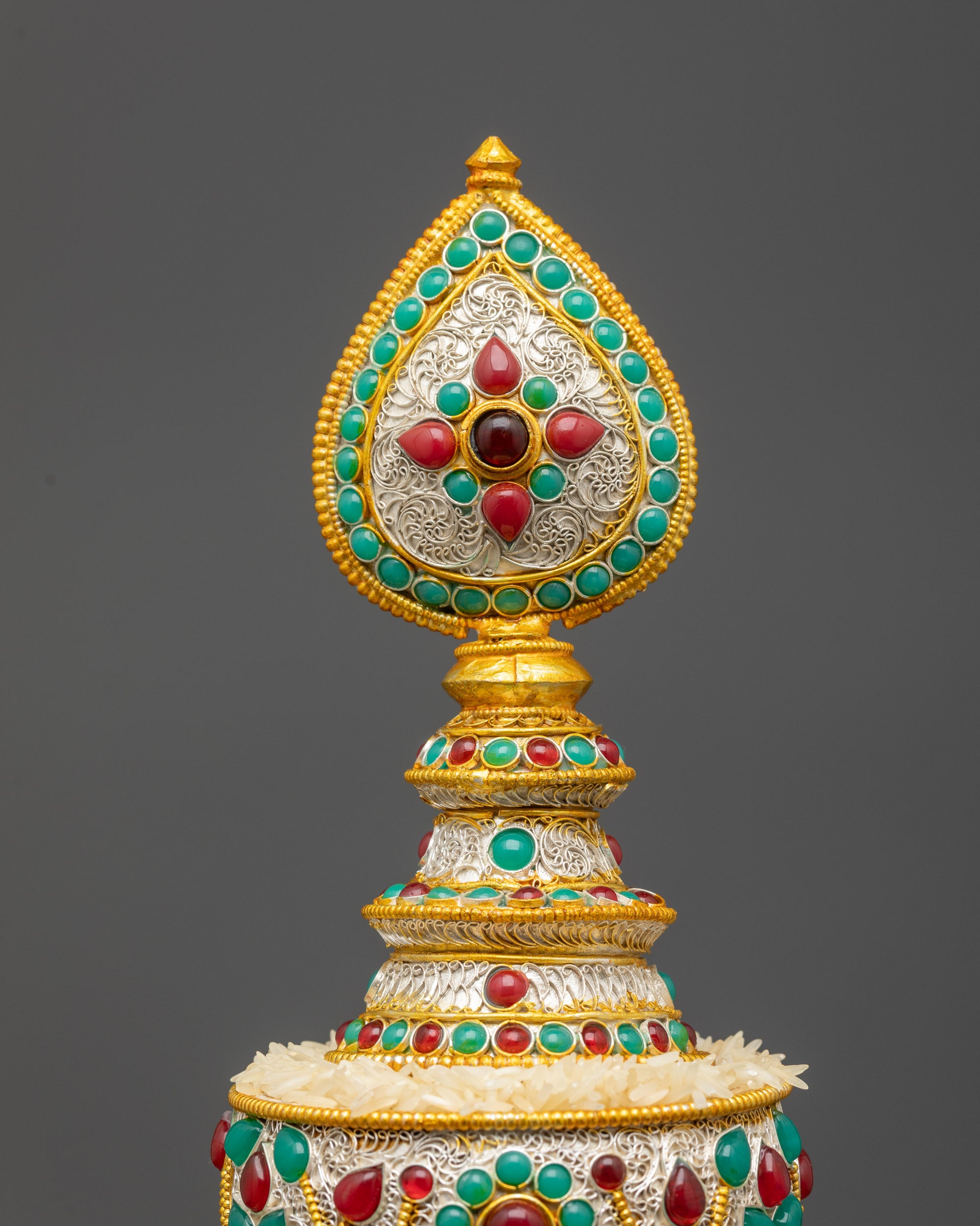 Side view Tibetan Mandala highlighting copper body coated with silver and decorative stones
