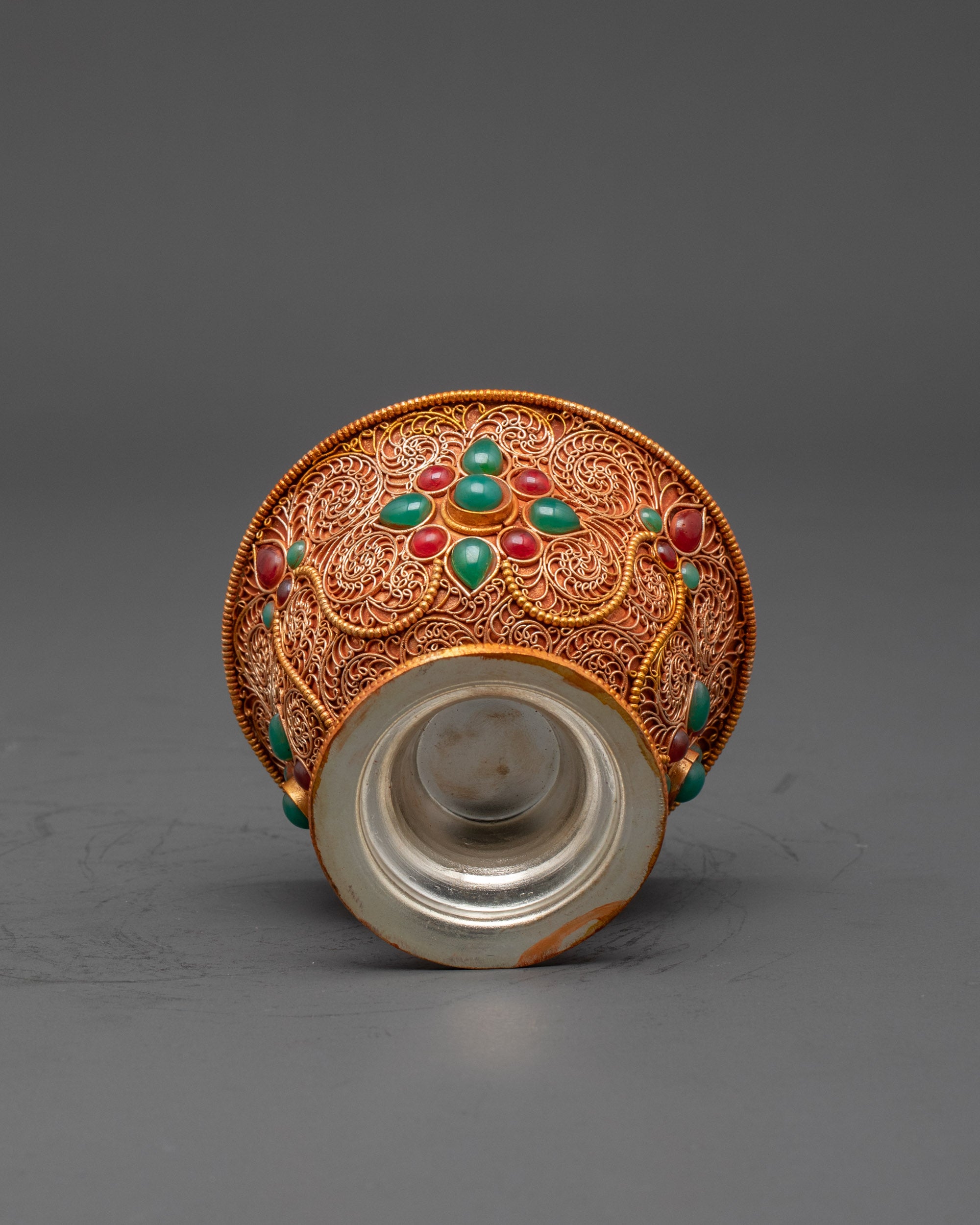 Side view Tibetan water offering bowl highlighting copper and gold filigree pattern