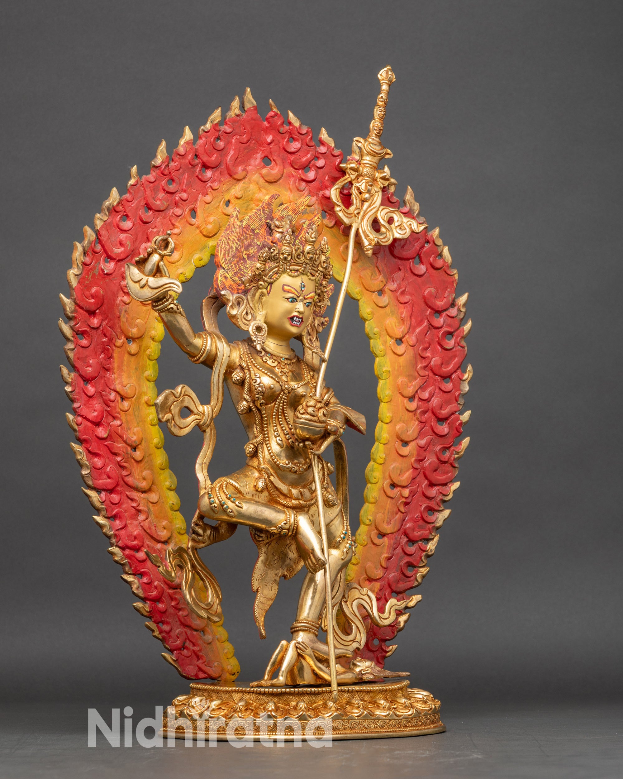 Close up Dorje Phagmo gold-gilded face with skull garland and ritual implements