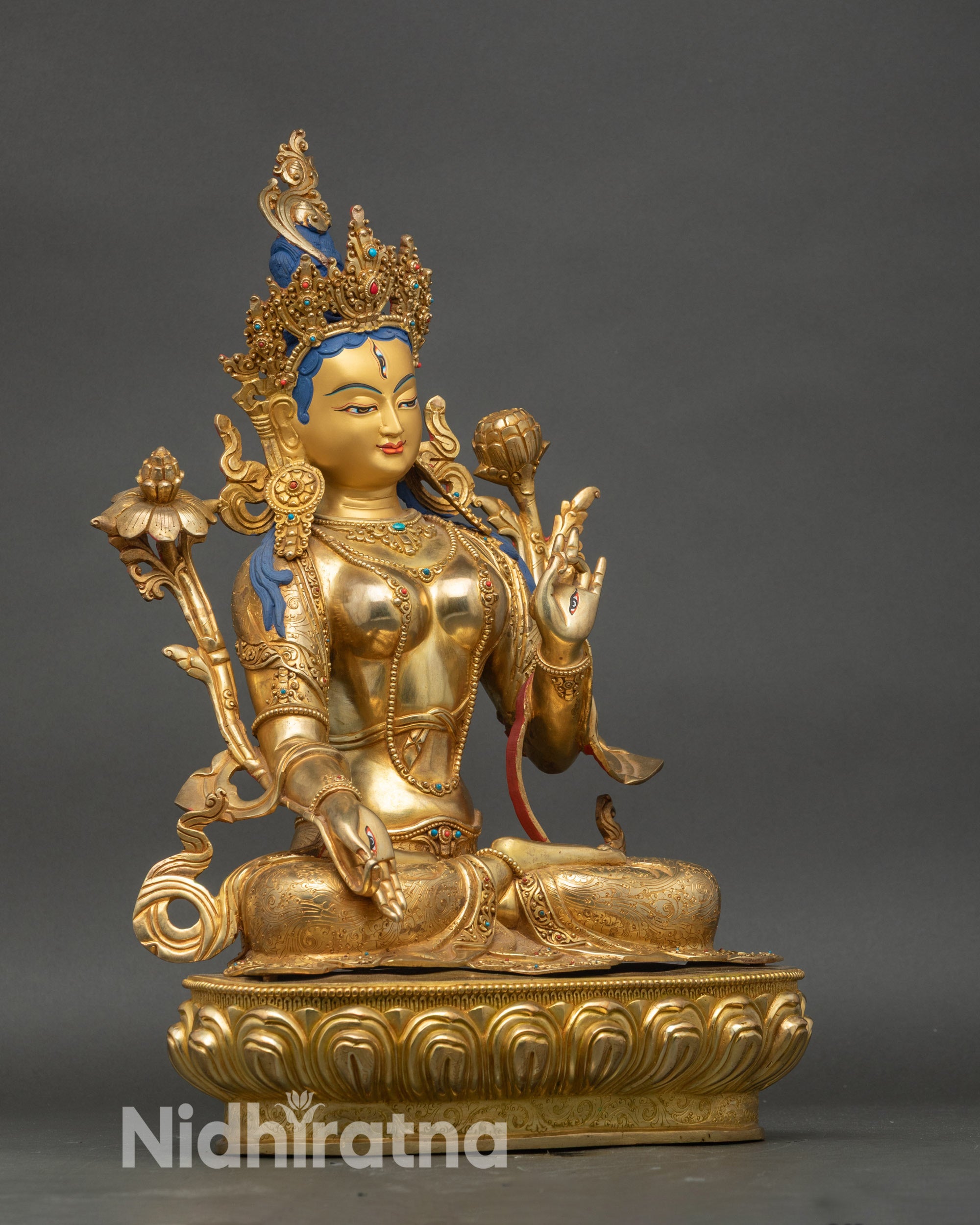 Side view White Tara sculpture showing flowing robe and sacred utpala flower in hand