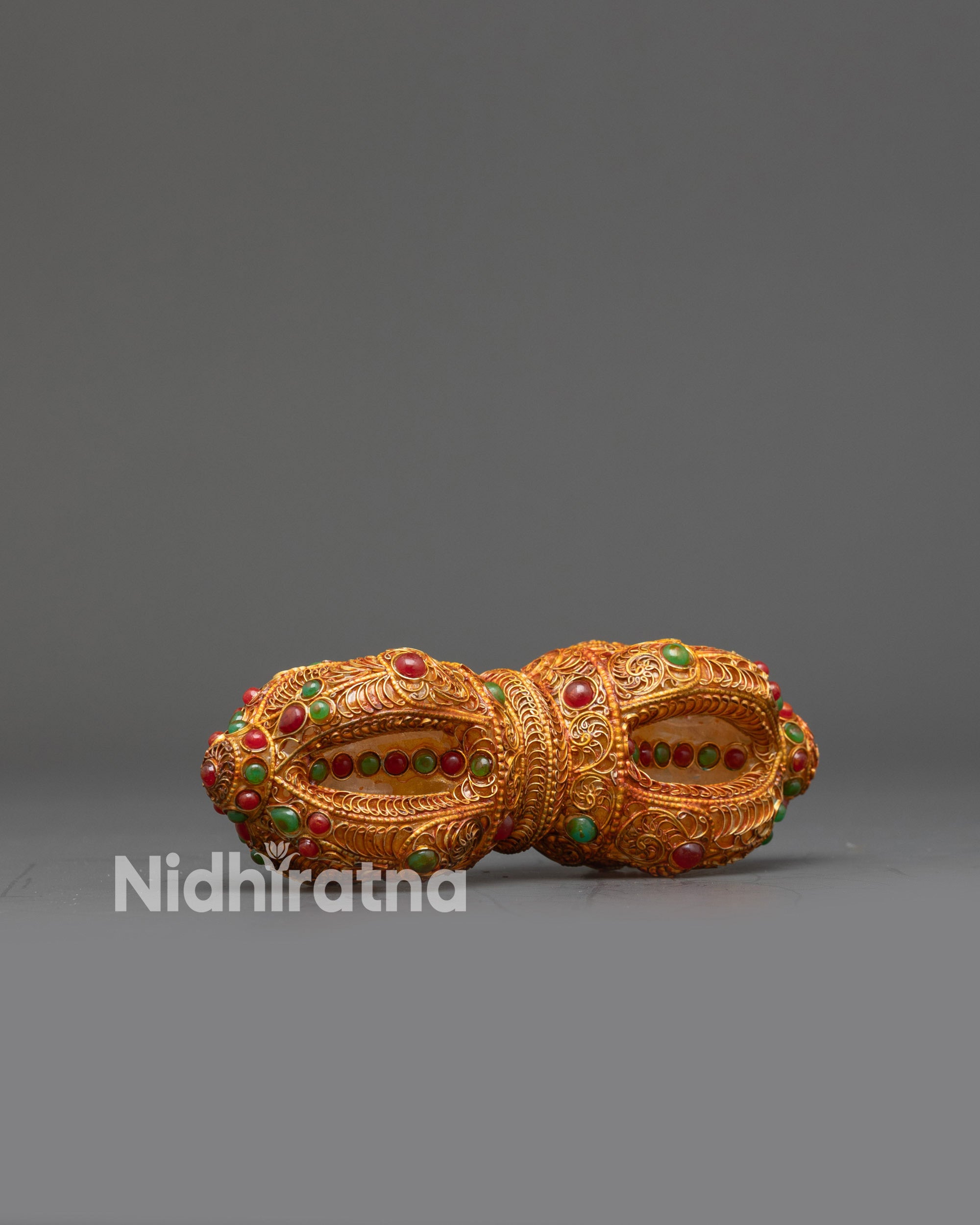 Side view double-ended Copper Vajra with ornate filigree and crystal center