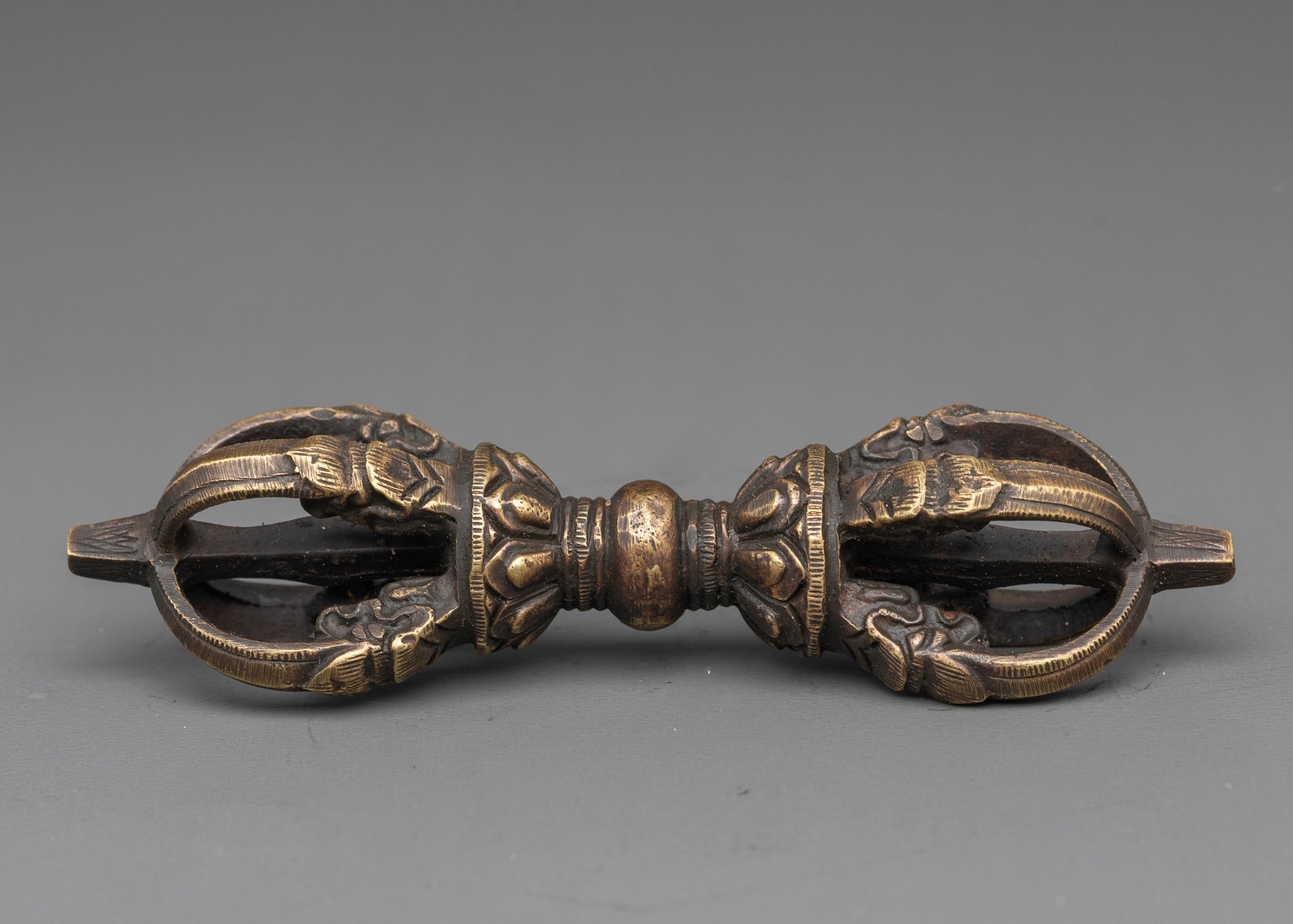 Side view intricate bronze vajra with detailed carvings for tantric ceremonies