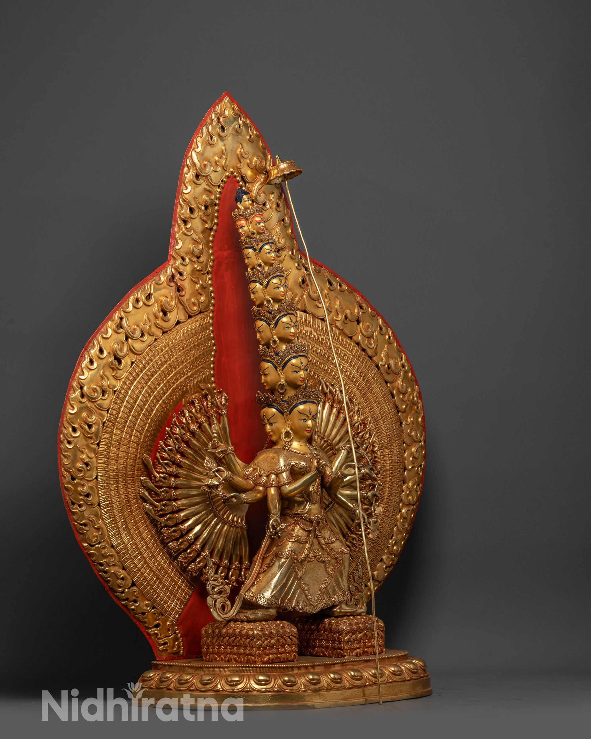 Side view of 1000-Arm Dukar Statue highlighting serene faces and radiant halo
