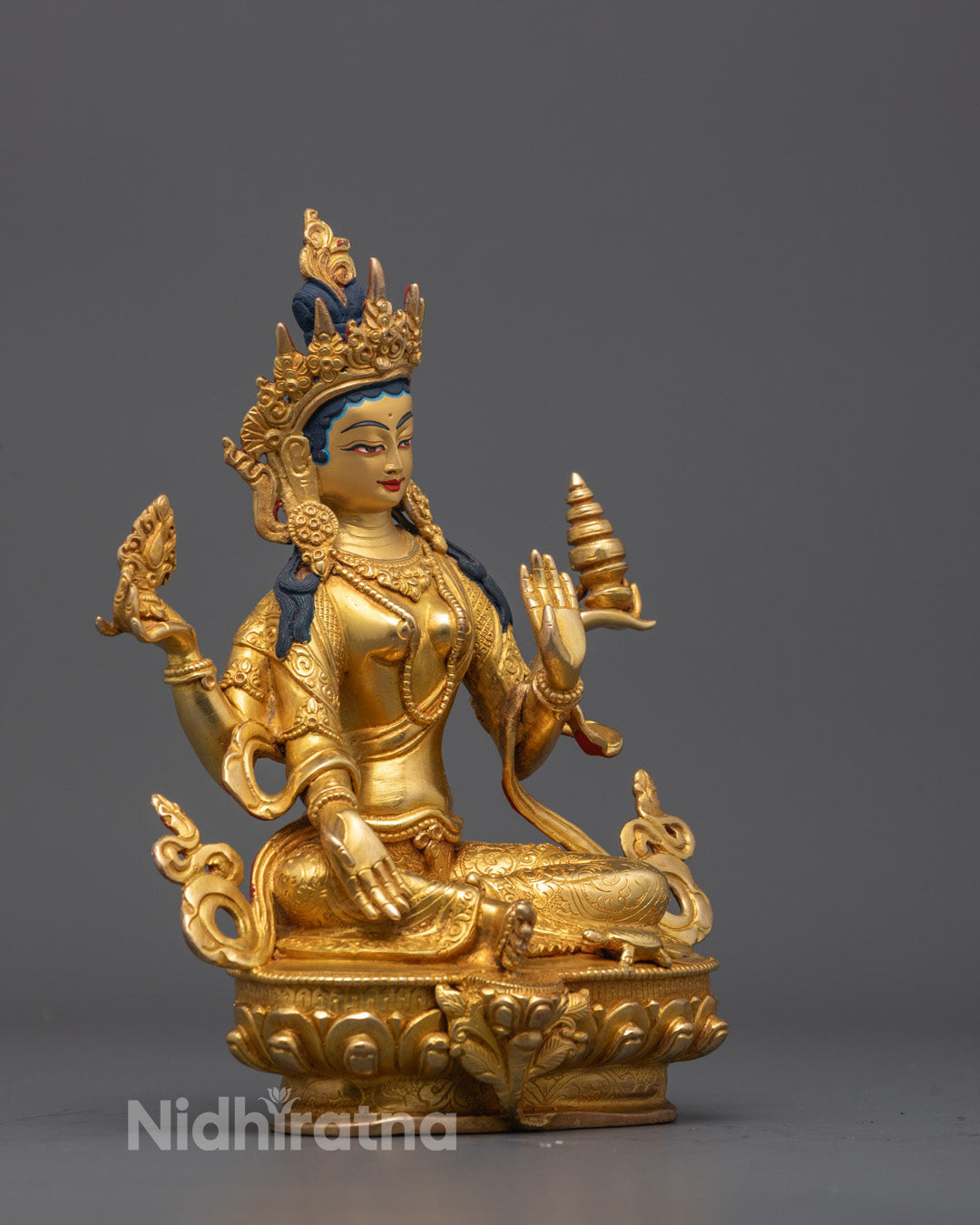 Side view of 24K gold fire-gilded Laxmi statue seated in royal ease pose