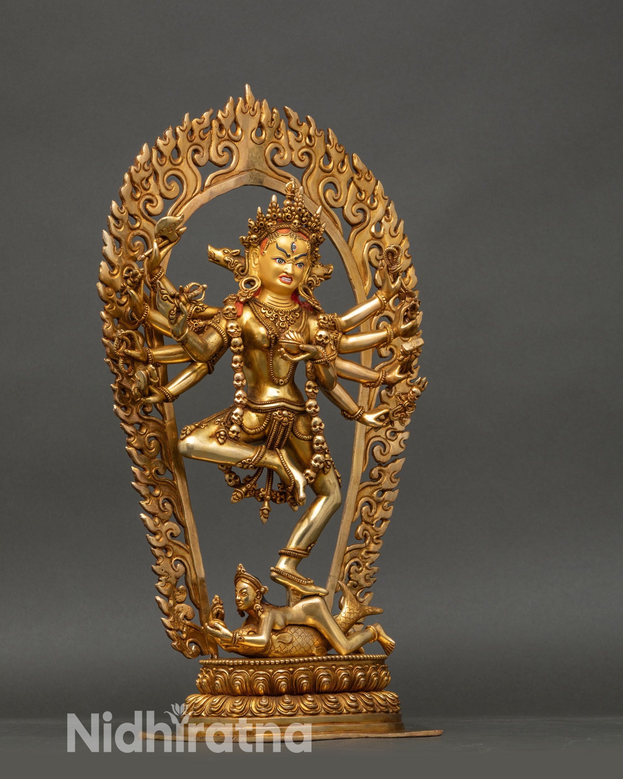 Side view of Dorje Phagmo copper statue standing on a lotus seat with sacred ritual objects in hands