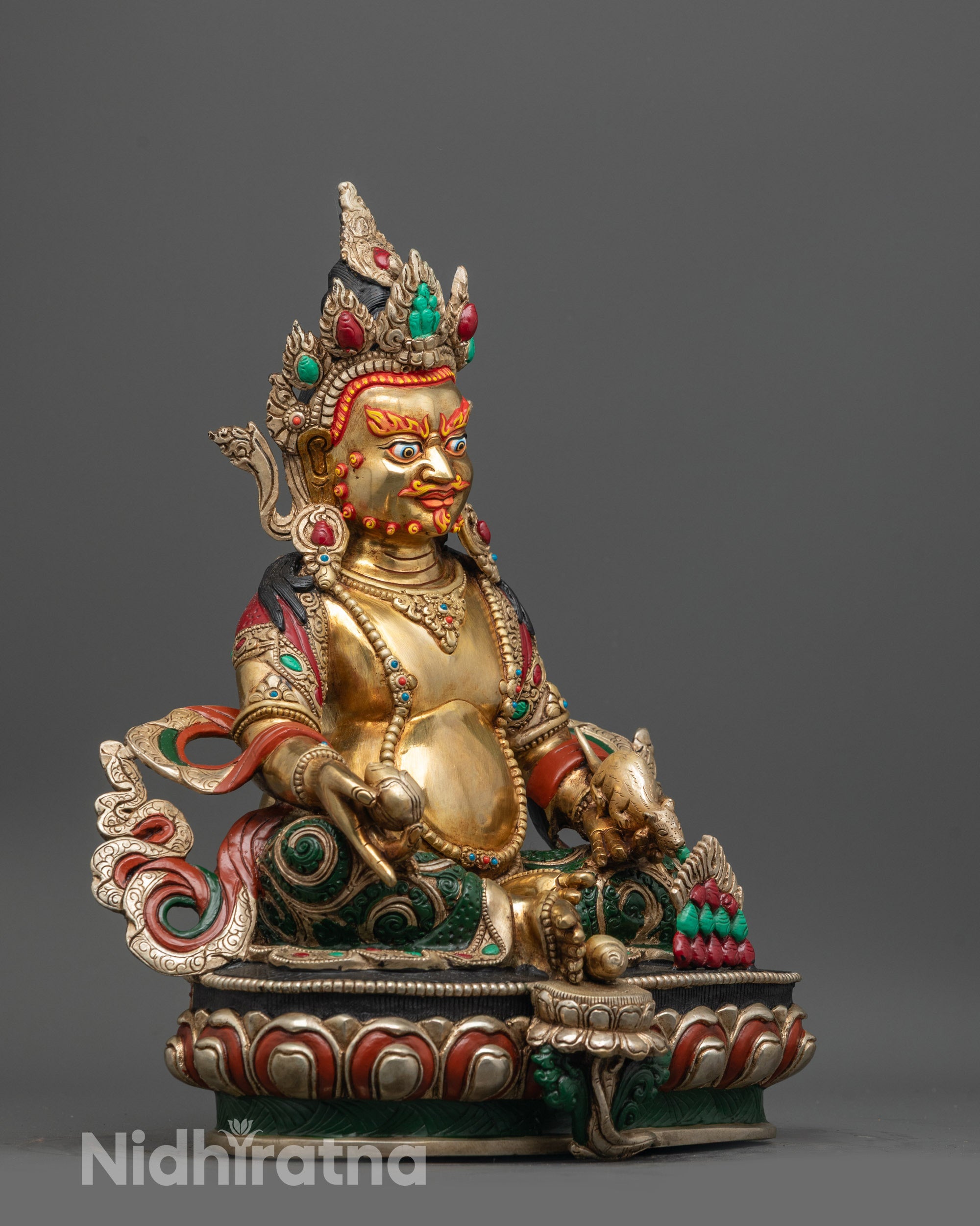 Side view of Dzambhala Statue seated on lotus with royal ease pose and foot near the shell