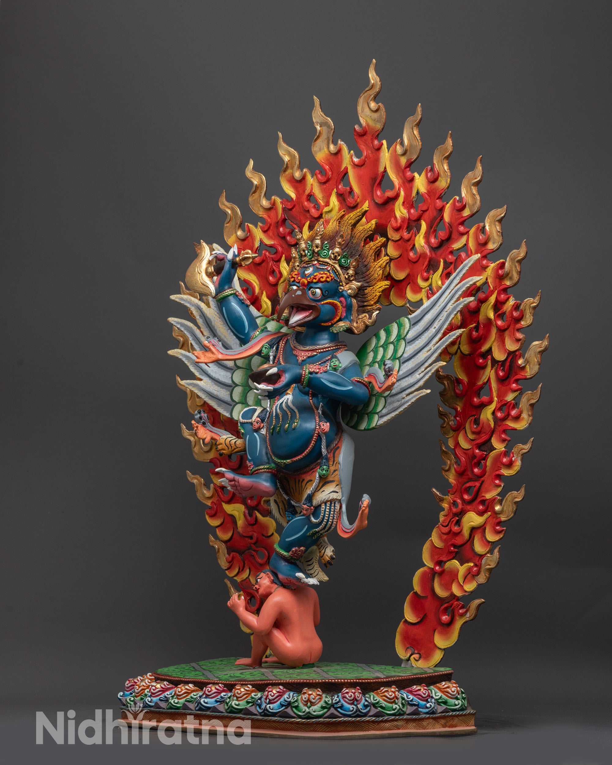 Side view of Garuda Statue highlighting carved wings and painted flaming halo
