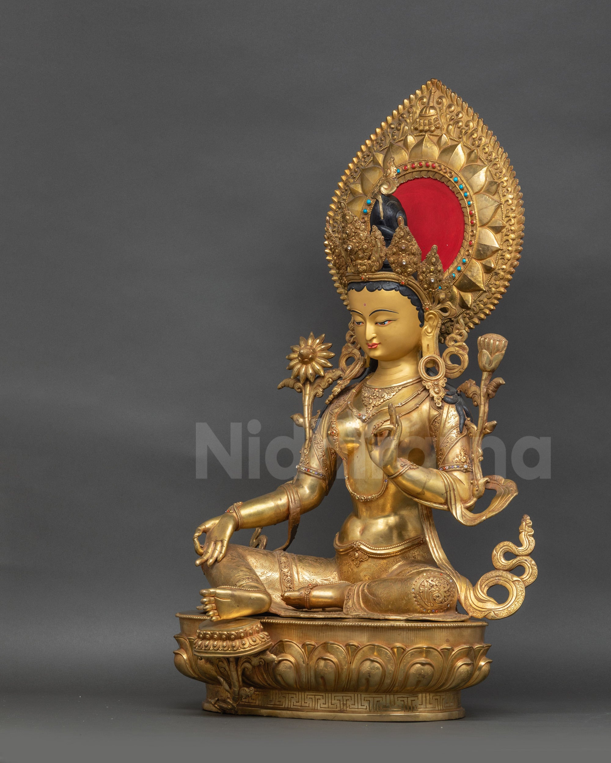 Side view of Green Tara sculpture showing lotus seat and robe with semi-precious stones