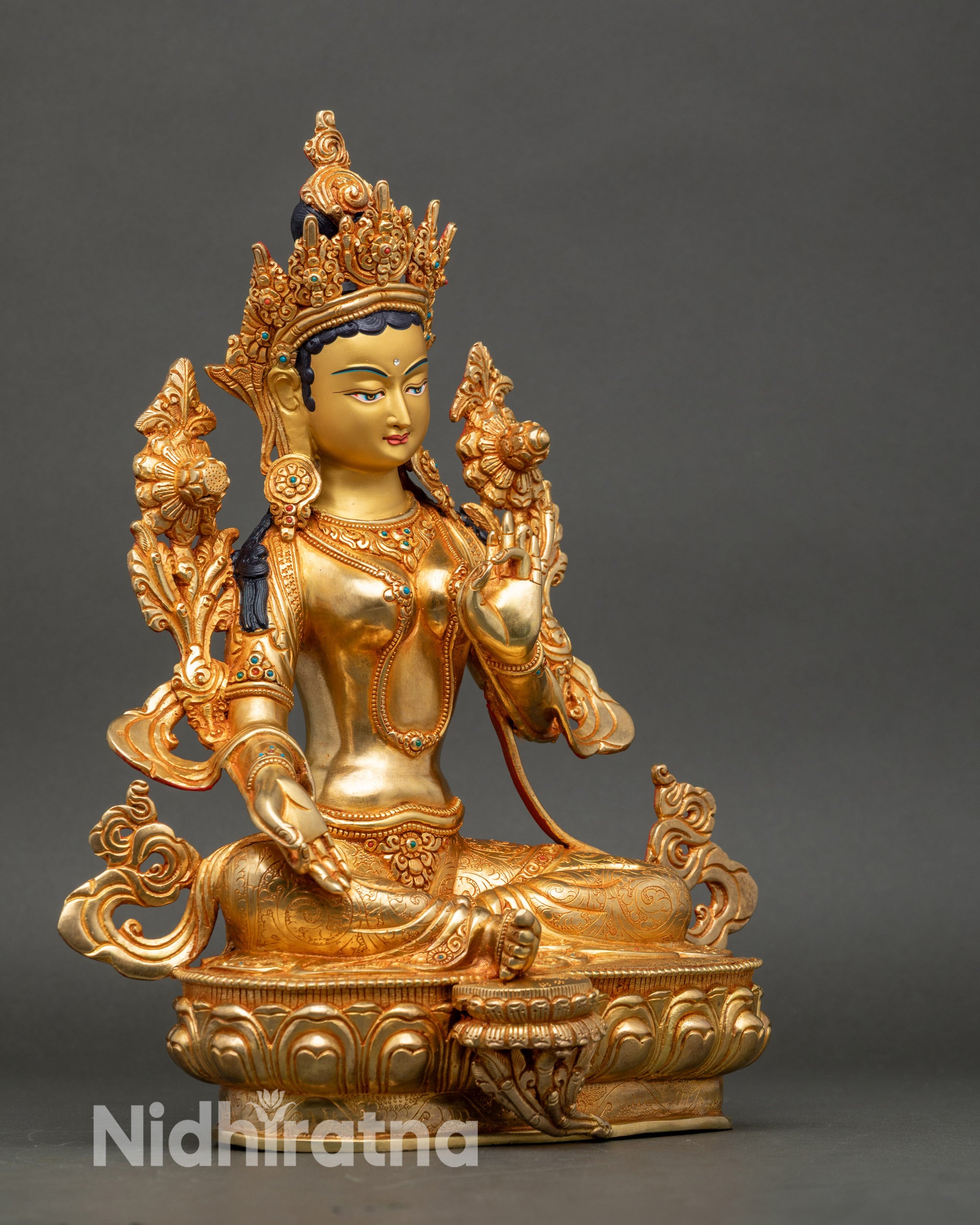 Side view of Green Tara statue holding Utpala stem, right hand in Varada Mudra, left in Vitarka Mudra