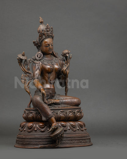 Side view of Green Tara statue holding utpala flowers, Nepalese meditation figure