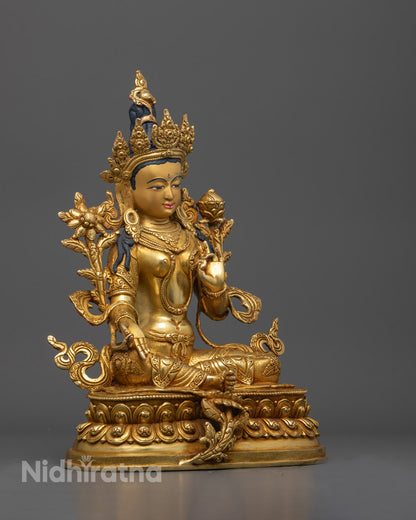 Side view of Green Tara statue seated in royal ease on a layered lotus base
