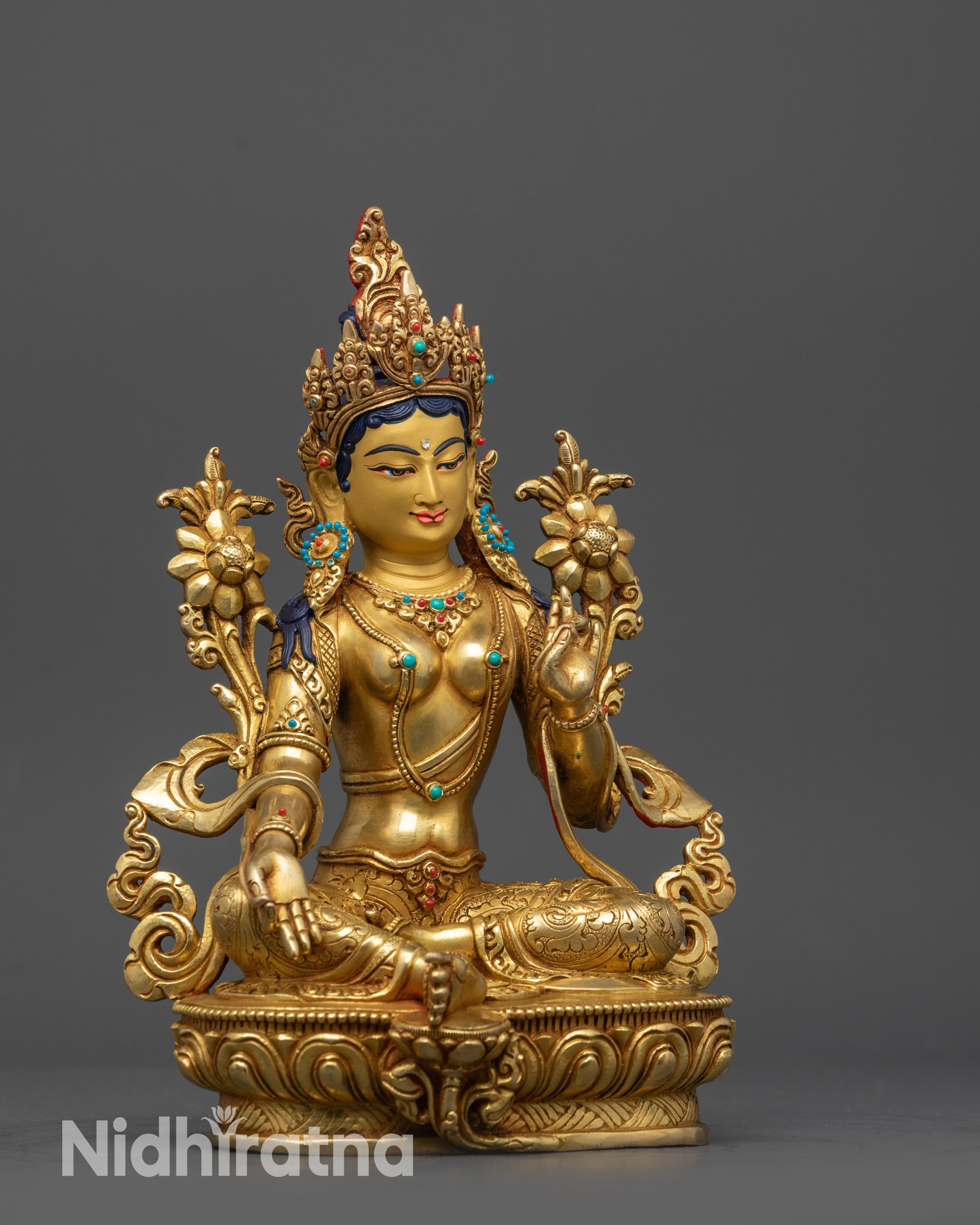Side view of Green Tara statue seated on intricately carved lotus throne