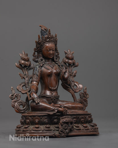Side view of Green Tara statue with oxidized copper finish seated gracefully