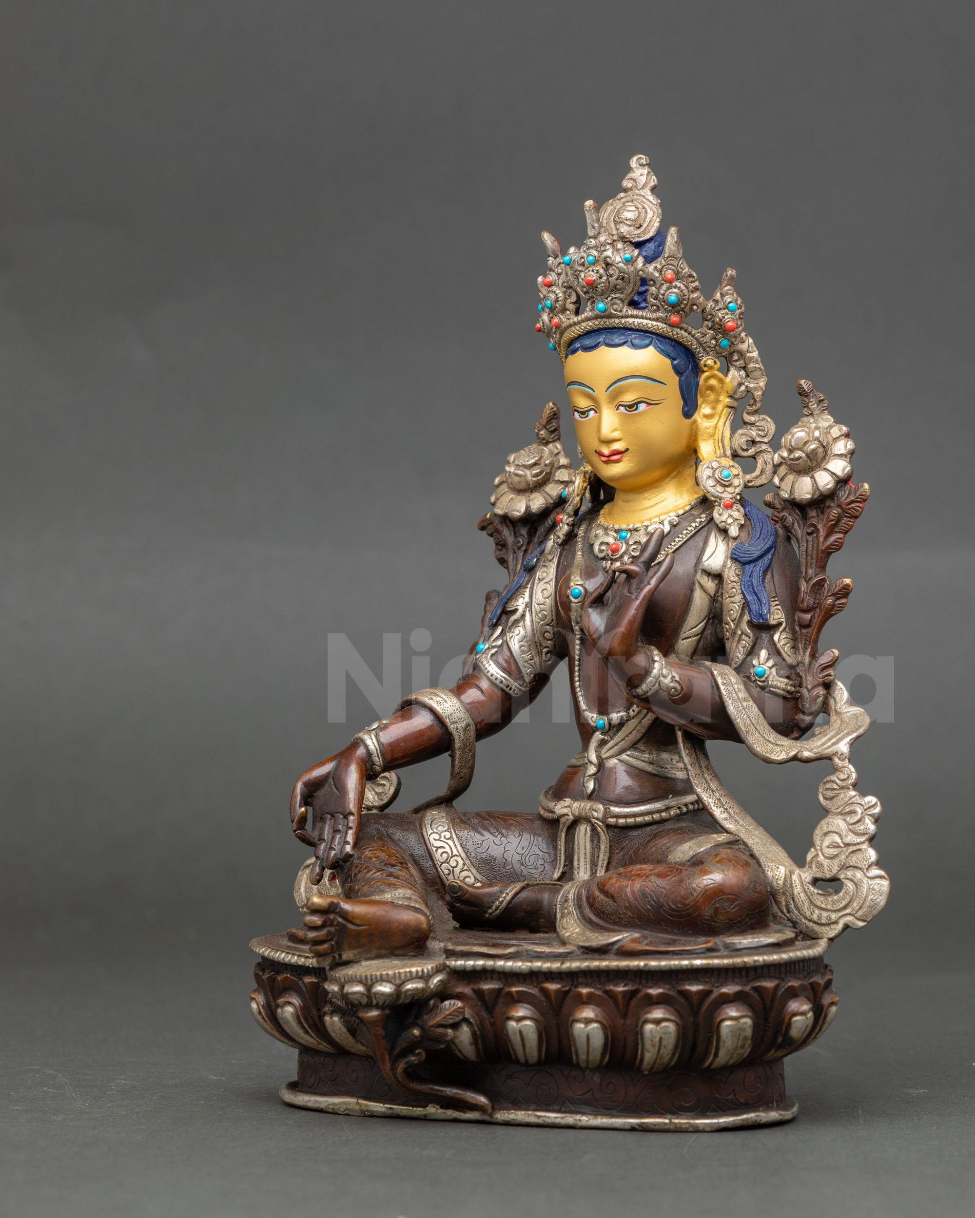 Side view of Green Tara statue with silver-plated finish and lotus seat detail
