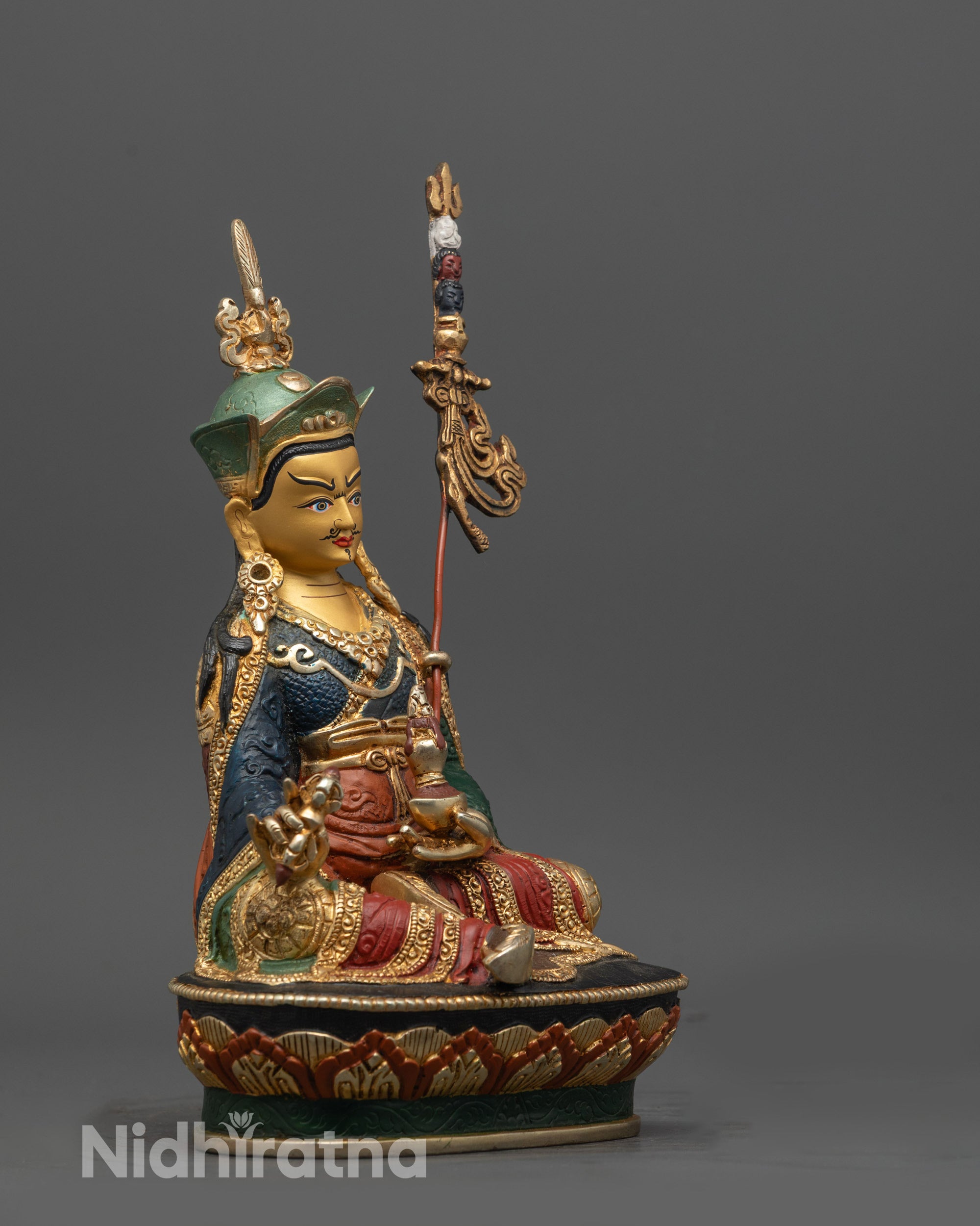 Side view of Guru Padmasambhava holding trident and kapala on multi-colored lotus seat
