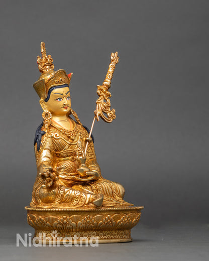Side view of Guru Rinpoche deity sculpture holding vajra and kalash, lotus throne detail