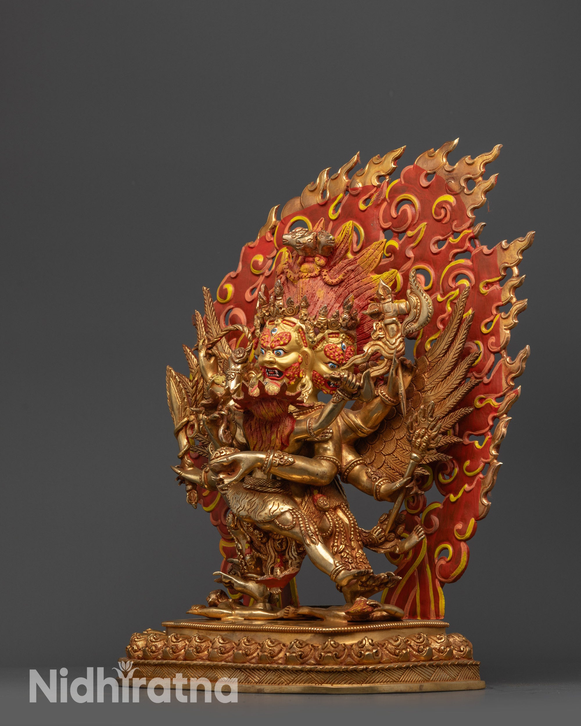 Side view of Hayagriva Statue with wings, multiple arms, and carved jewelry visible
