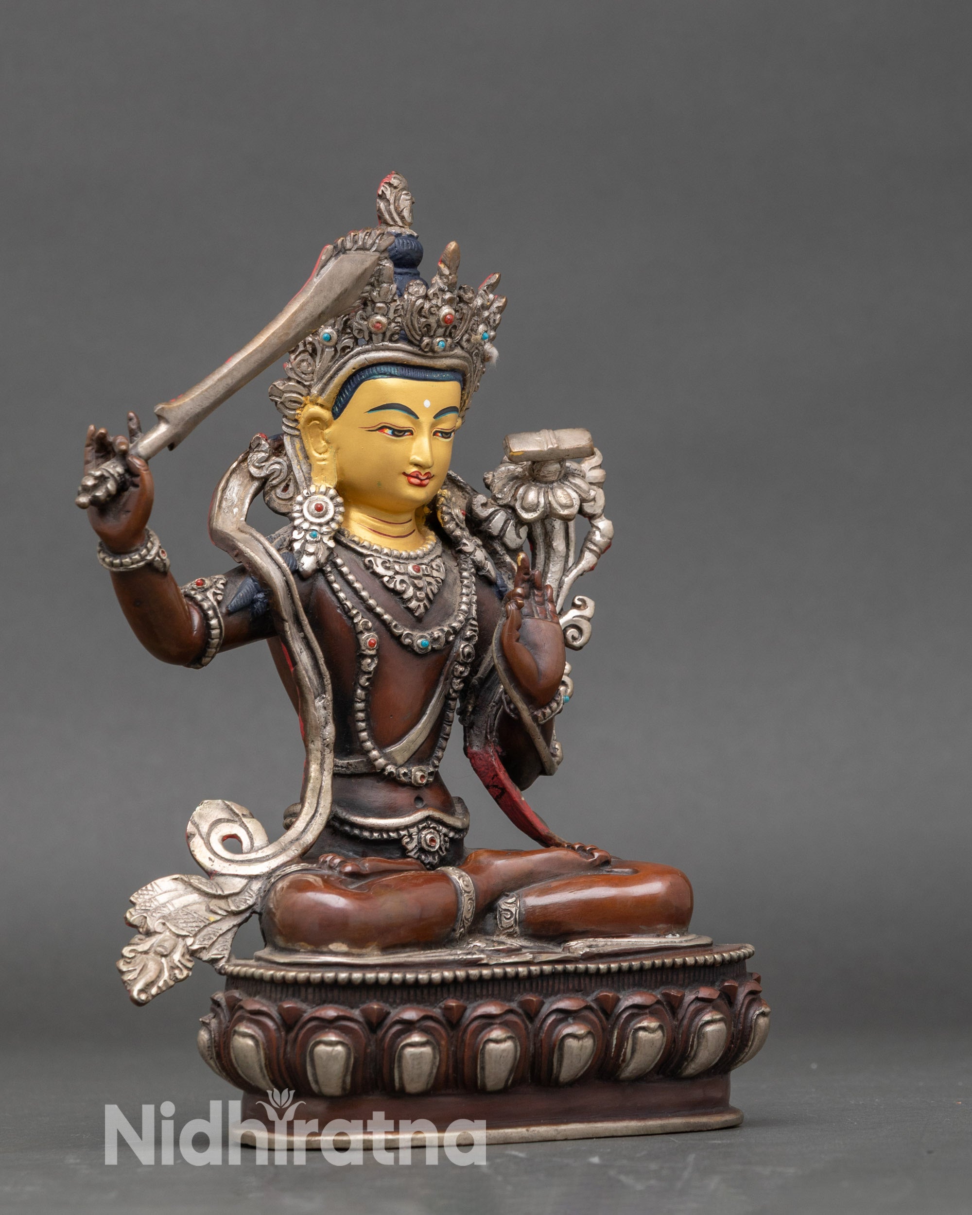 Side view of Manjushri statue showing flowing robes and serene meditation posture