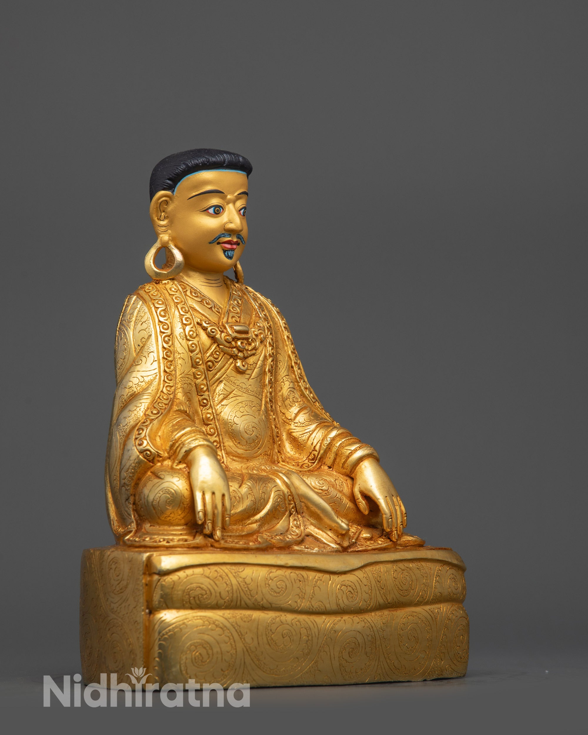 Side view of Marpa Statue seated in serene meditation pose on copper base
