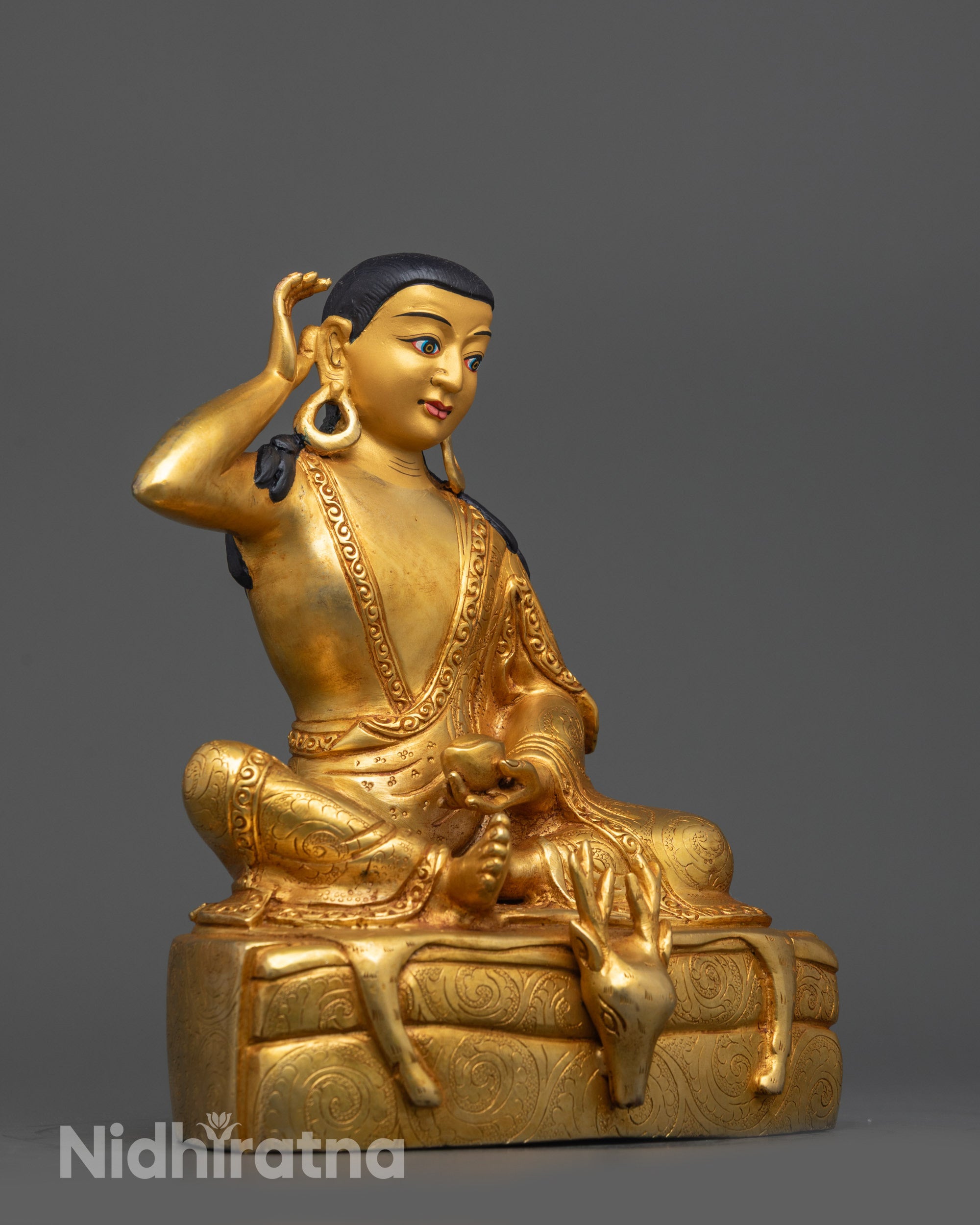 Side view of Milarepa Statue seated on deer skin with carved robes and gold fire-gilded body
