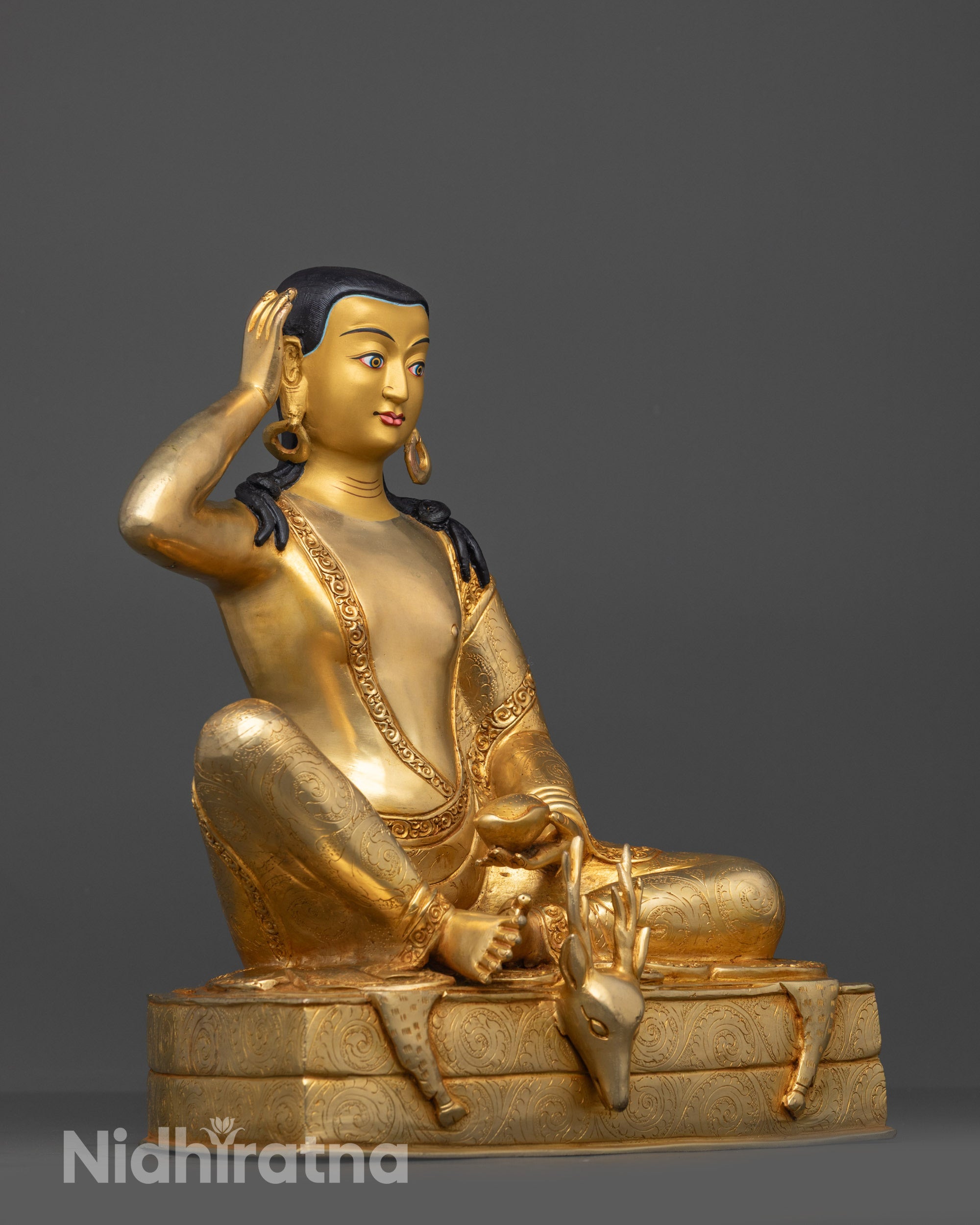 Side view of Milarepa Statue seated on deer skin with finely carved robe and seat details