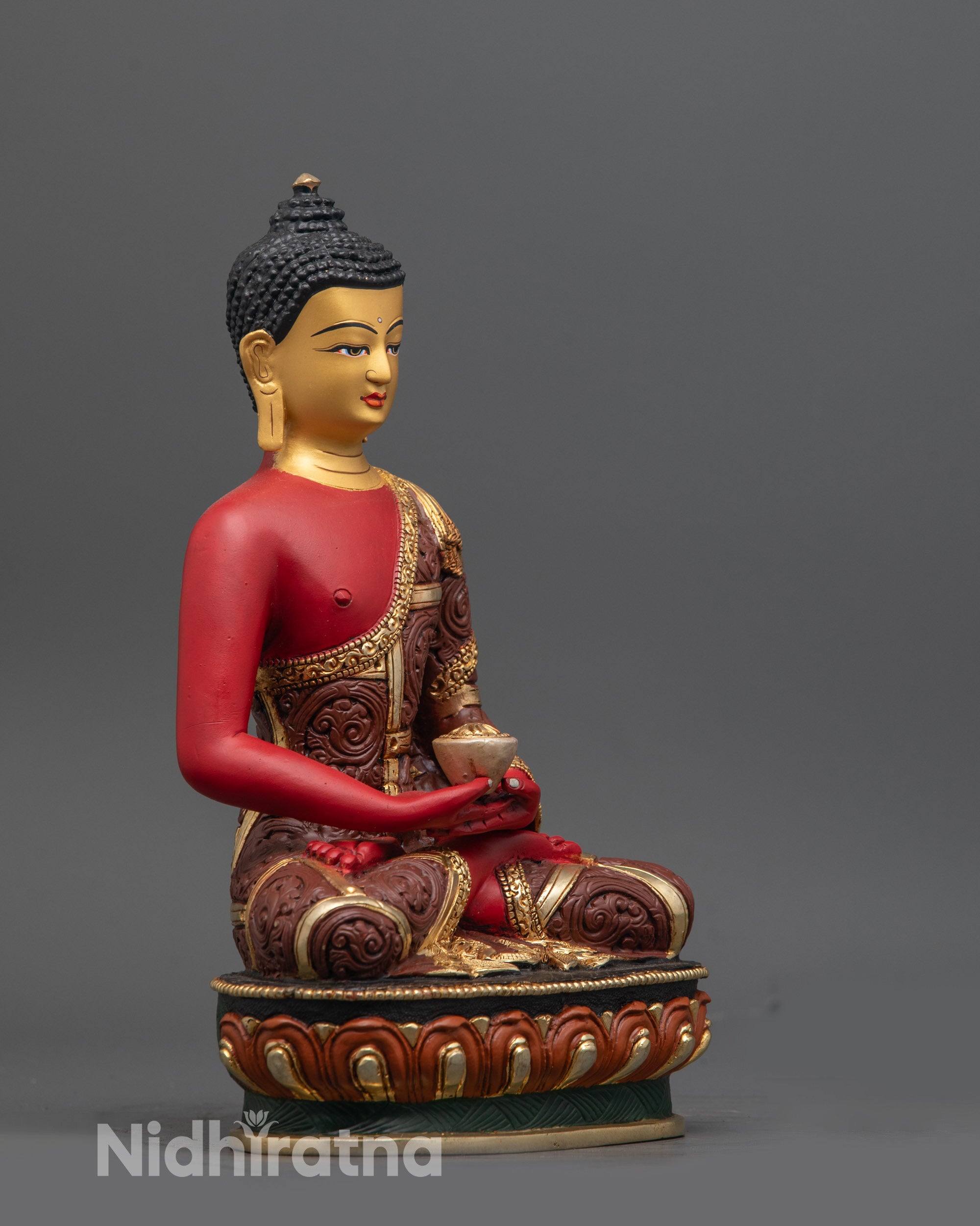Side view of Nepalese Amitabha Buddha statue with coloured robe and monk's bowl