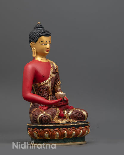 Side view of Nepalese Amitabha Buddha statue with coloured robe and monk's bowl