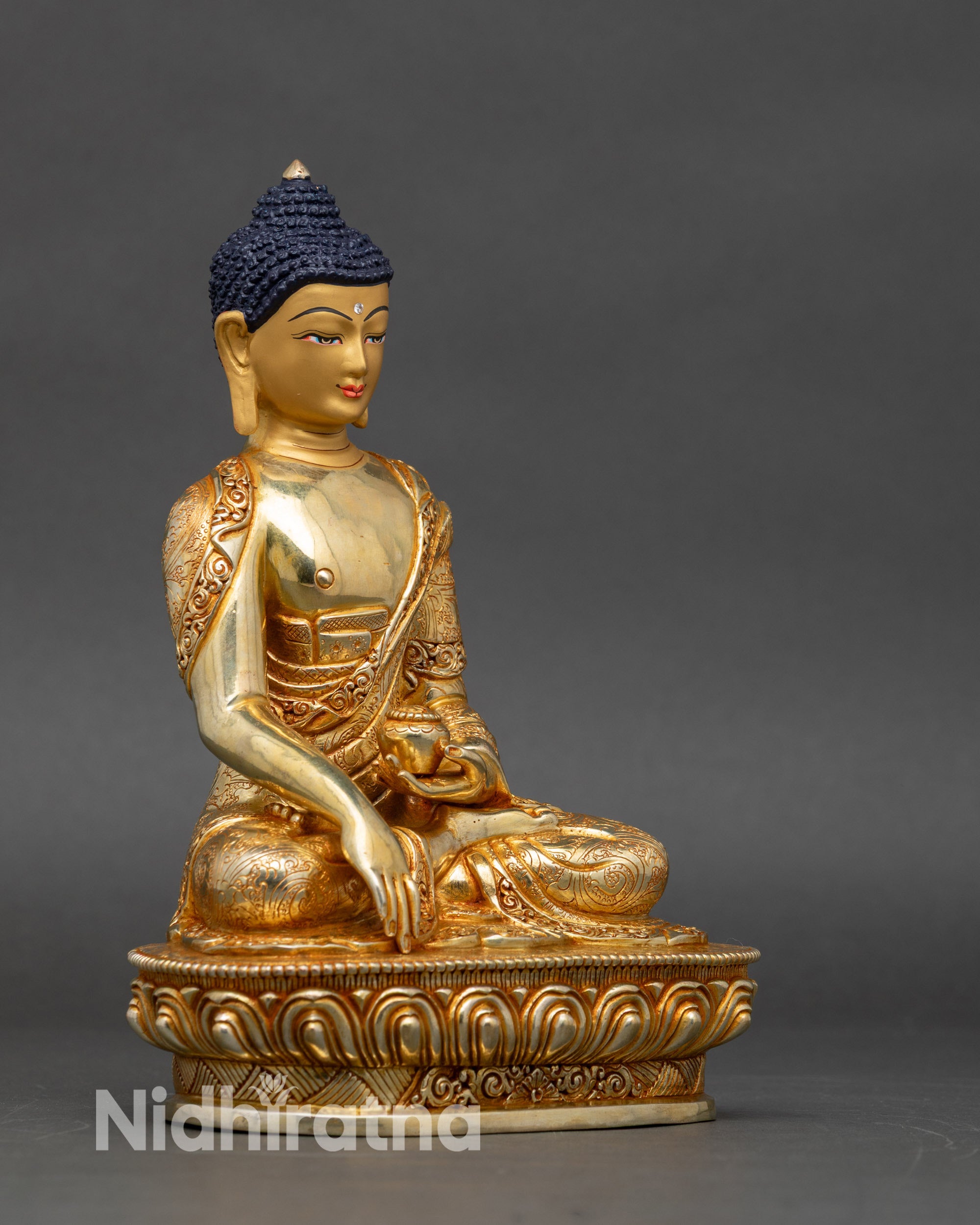 Side view of Nepalese Buddha statue, radiant gold fire-gilded details for home altar