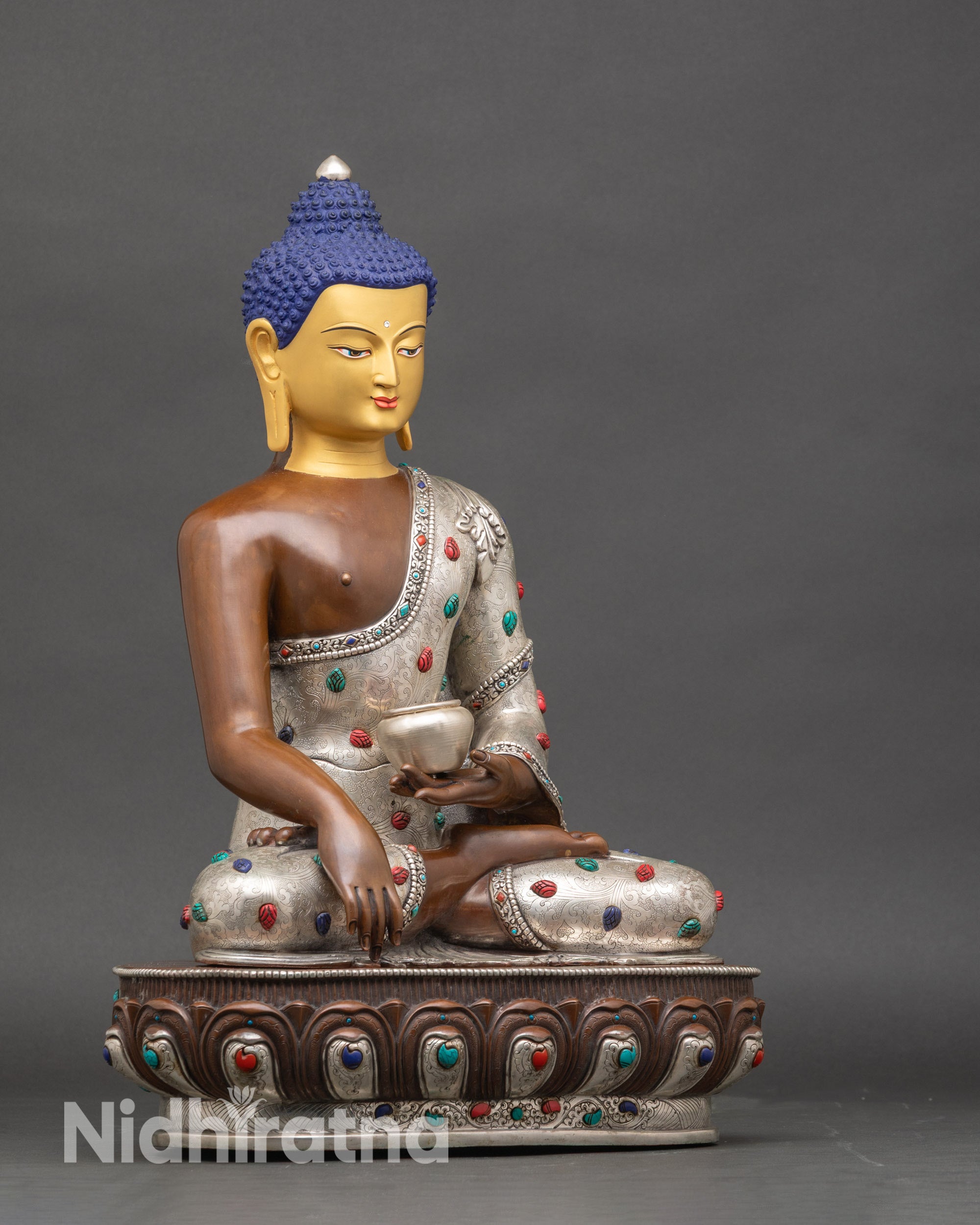 Side view of Nepalese Buddha statue seated on lotus throne for meditation