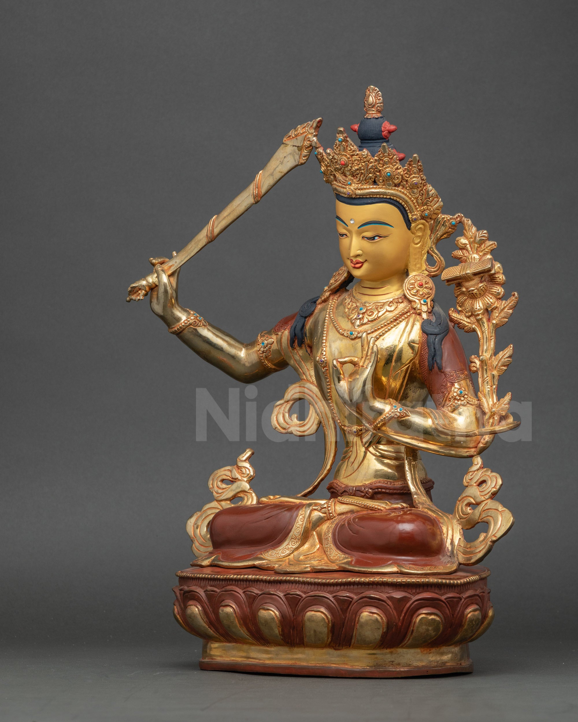 Side view of Nepalese Manjushri statue highlighting lotus seat and vibrant gold gilding