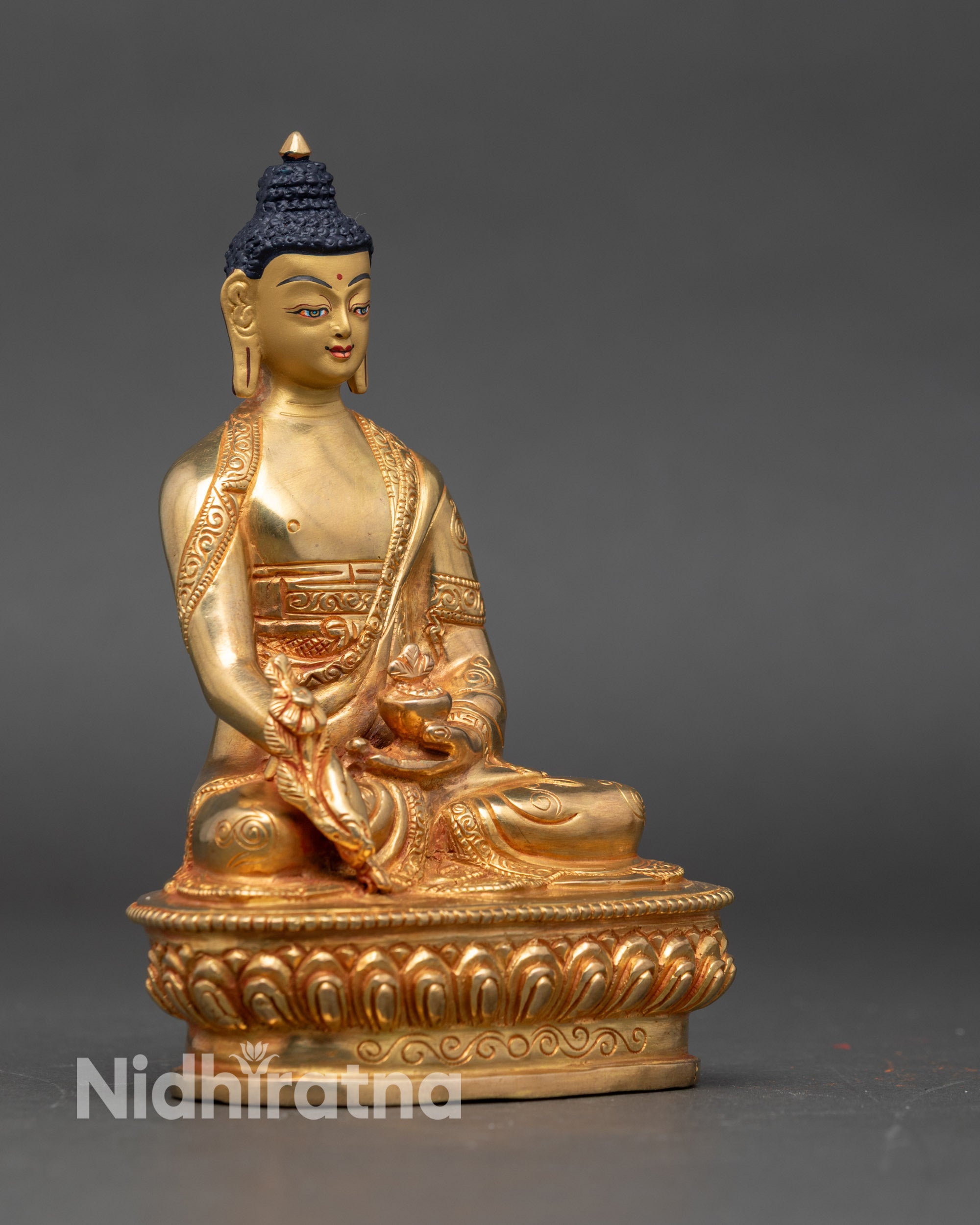 Side view of Nepalese Medicine Buddha on lotus throne holding medicinal bowl and healing herb