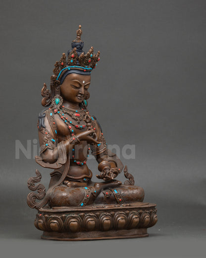 Side view of Nepalese Vajrasattva figurine with sacred bell and vajra