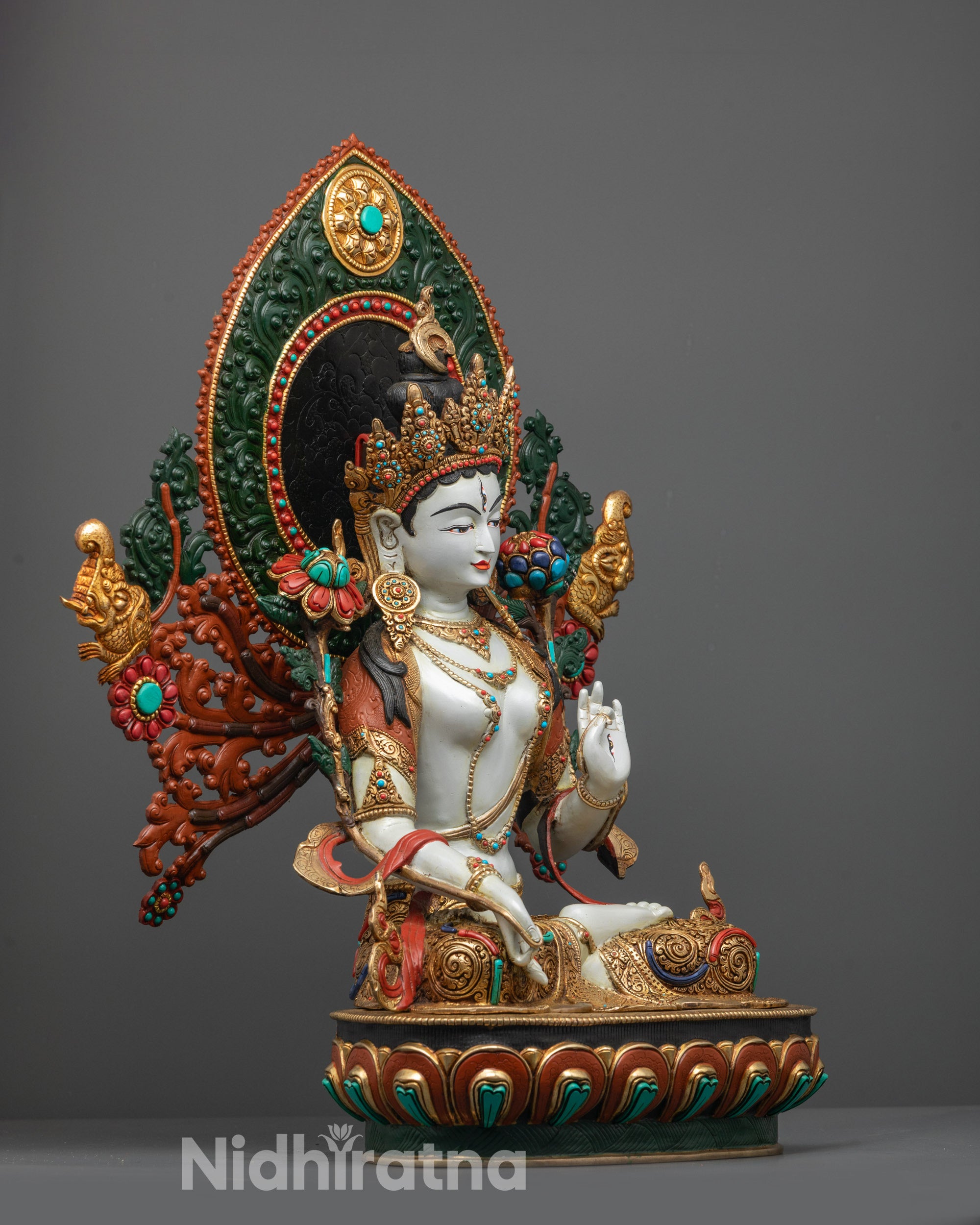 Side view of Nepalese White Tara Sculpture on coloured lotus seat with halo backdrop