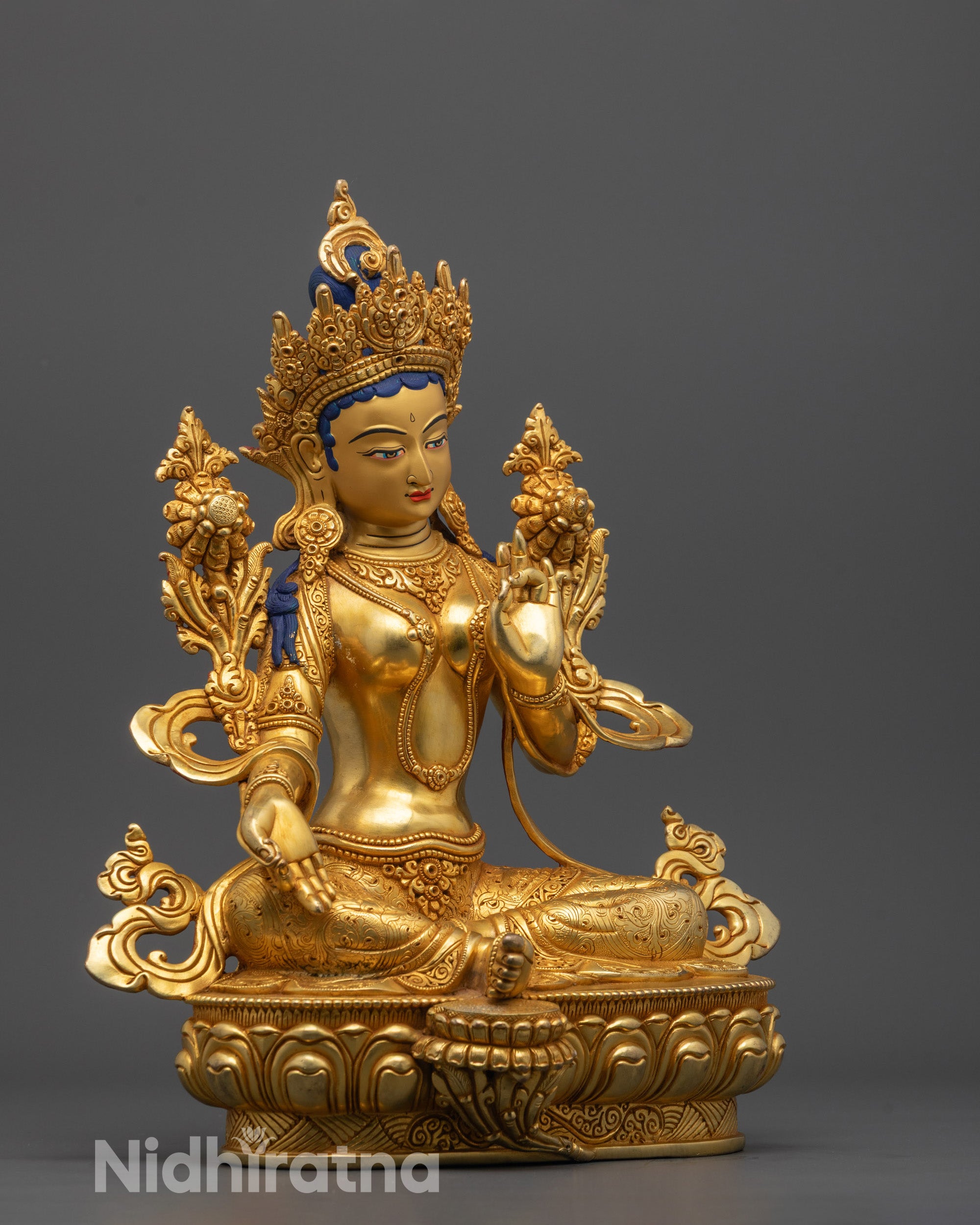 Side view of Nepalese artisan using lost wax method to craft detailed Green Tara Buddha statue
