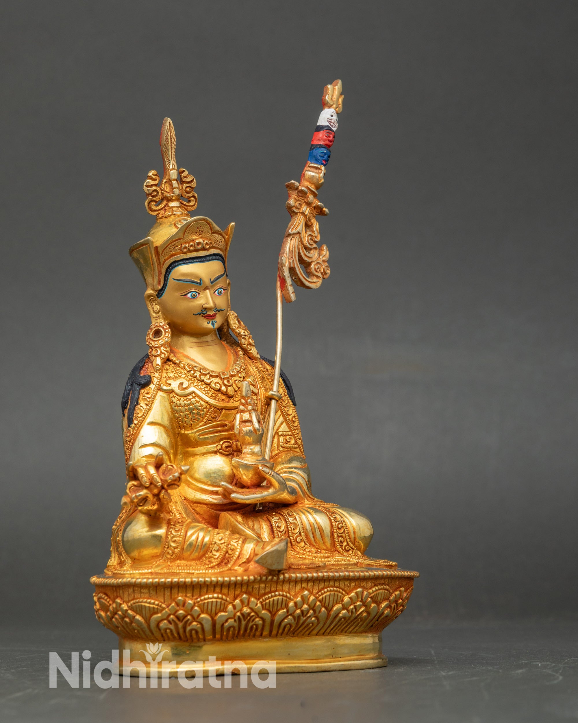 Side view of Padmasambhava Buddhist statue, intricate lost-wax copper and gold detailing