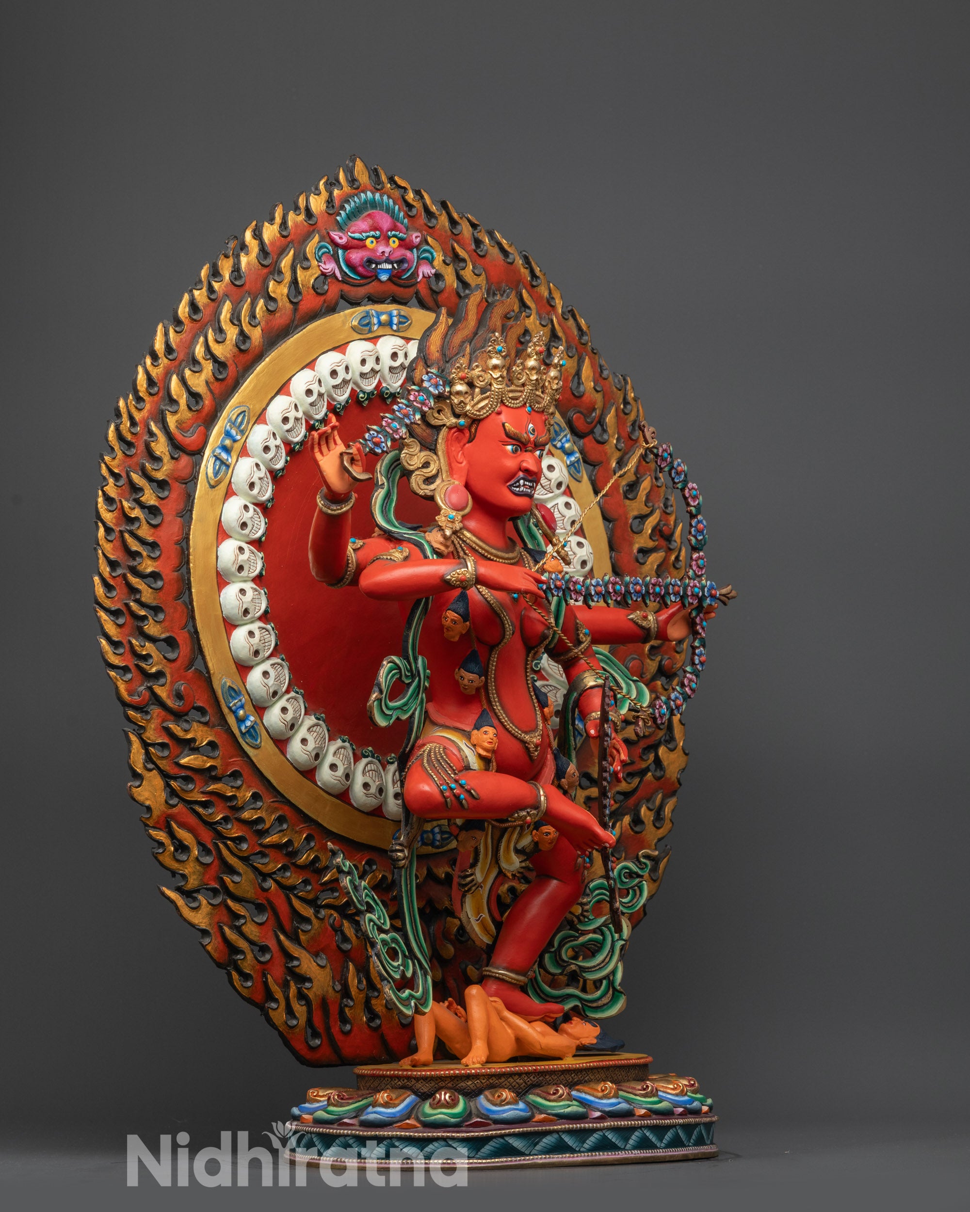 Side view of Red Kurukulla Statue holding hook, noose, and floral bow and arrows