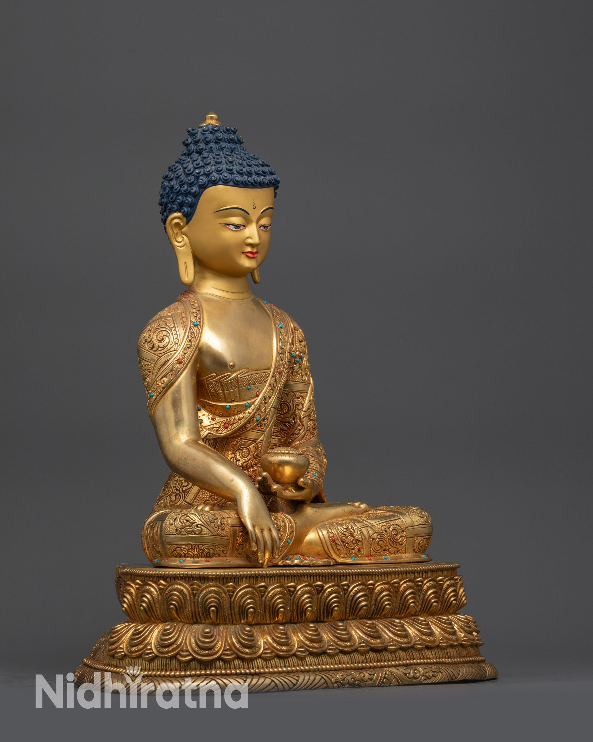 Side view of Shakyamuni Buddha statue holding alms bowl with detailed patterns
