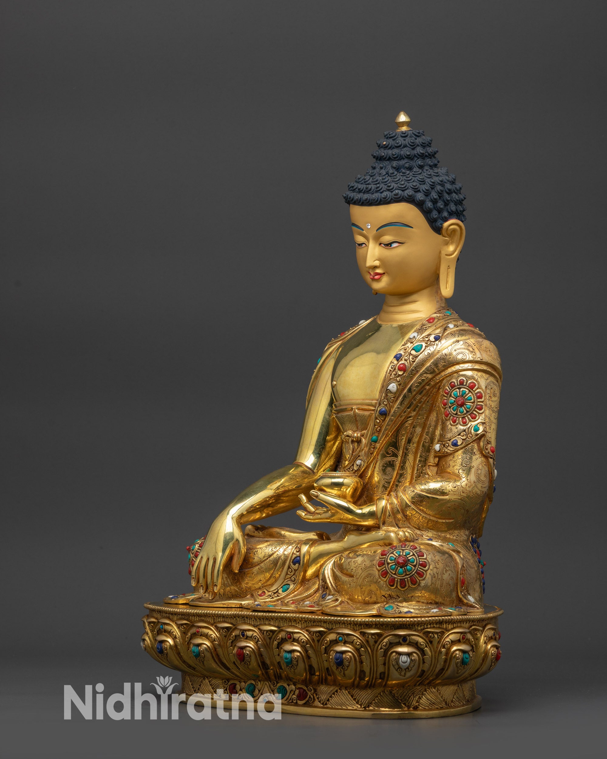 Side view of Shakyamuni Buddha with intricately carved robe and semi-precious stones